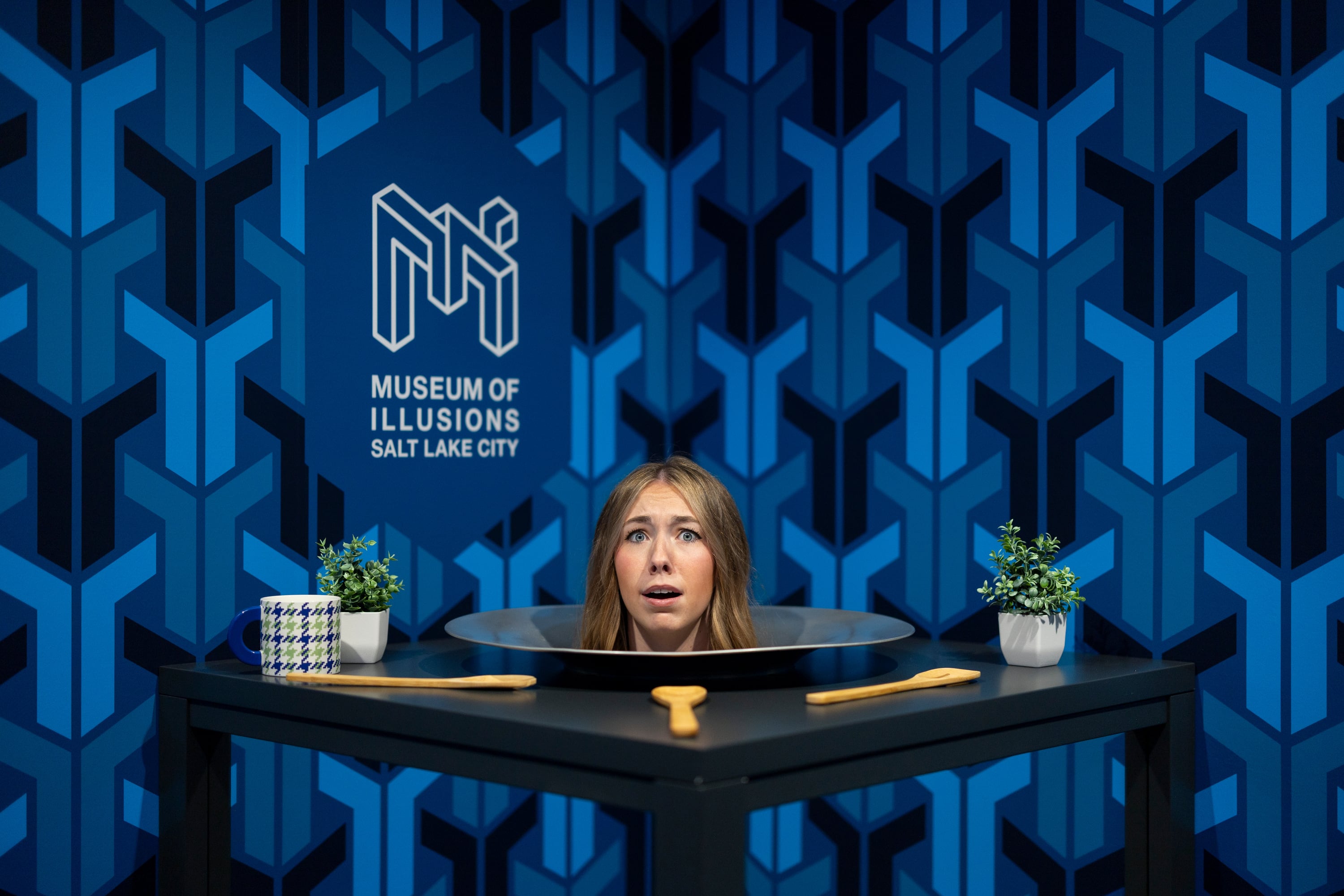 Kaycie Olney poses for a photo in the “Head on a Platter” exhibit at the Museum of Illusions in Salt Lake City on Thursday.