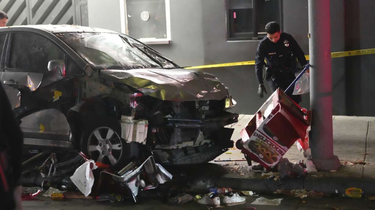 A vehicle sits on the sidewalk after ramming into a crowd waiting to enter a nightclub in Los Angeles early Saturday. Three people were critically injured, and the driver of the car was found with a gunshot wound.
