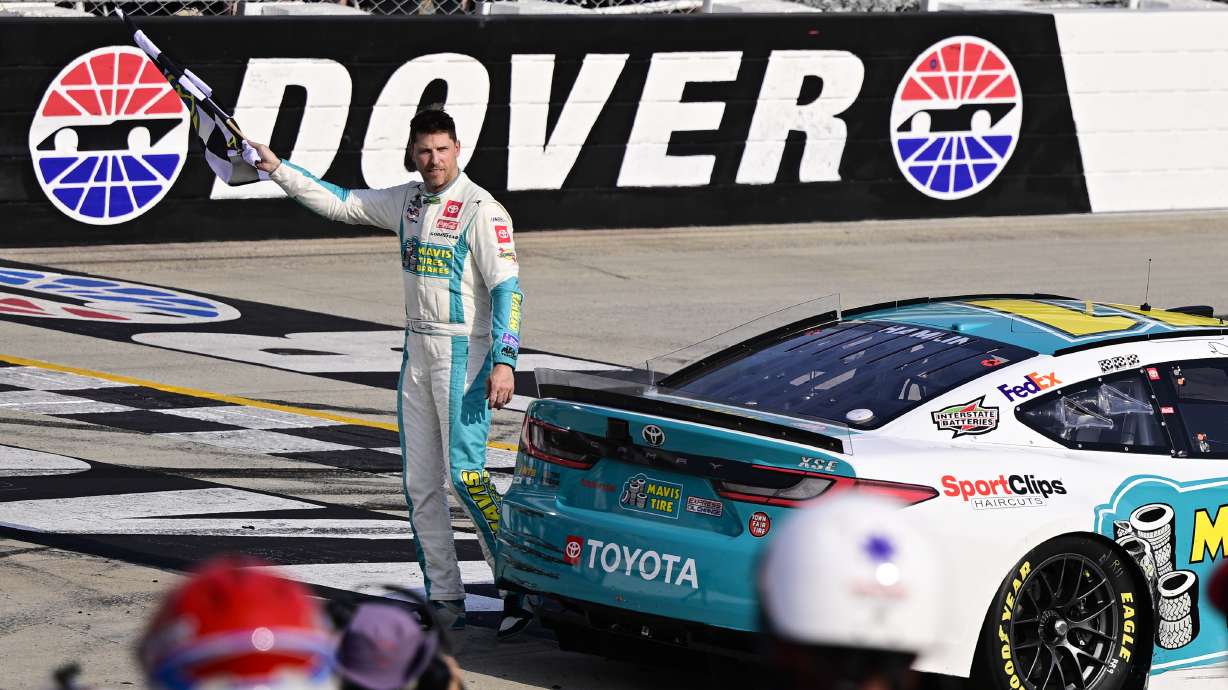 FILE - Denny Hamlin celebrates with the checkered flag after winning a NASCAR Cup Series auto race at Dover Motor Speedway, Sunday, April 28, 2024, in Dover, Del.