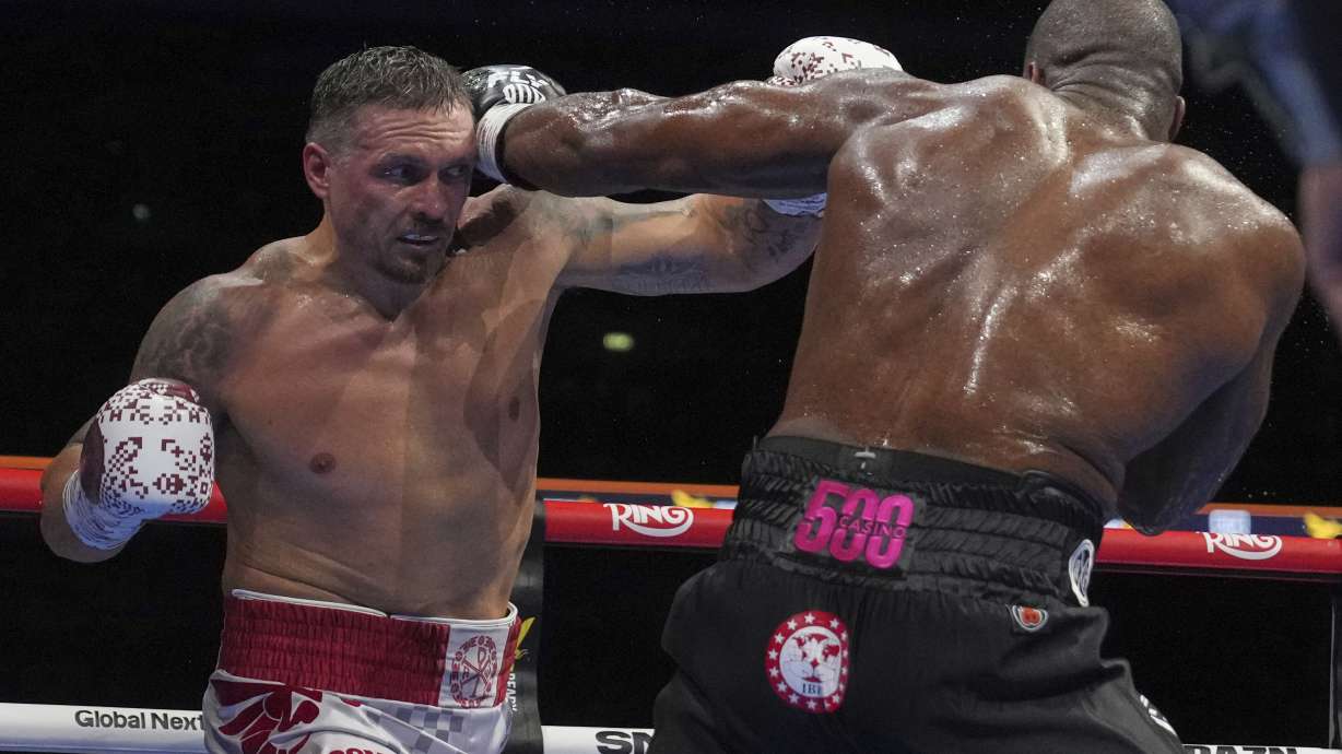 Ukraine's Oleksandr Usyk, left, and Britain's Daniel Dubois in action during the undisputed world heavyweight boxing title fight in London, Saturday, July 19, 2025.
