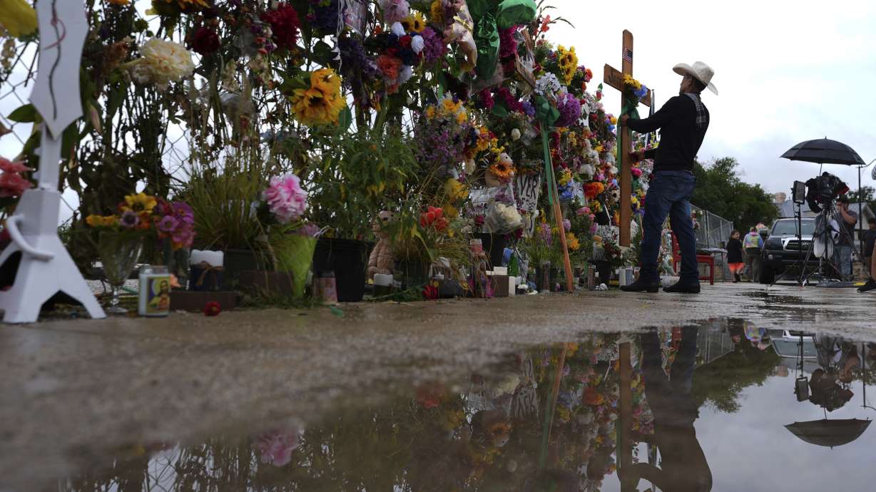 Roberto Marquez places a cross at a memorial wall for flood victims, Sunday, in Kerrville, Texas. Officials said Saturday just three people are still missing from deadly flooding that occurred on July 4.