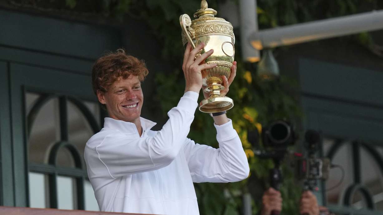 Italy's Jannik Sinner shows the trophy from the balcony of Centre Court after beating Carlos Alcaraz of Spain to win the men's singles final at the Wimbledon Tennis Championships in London, Sunday, July 13, 2025.
