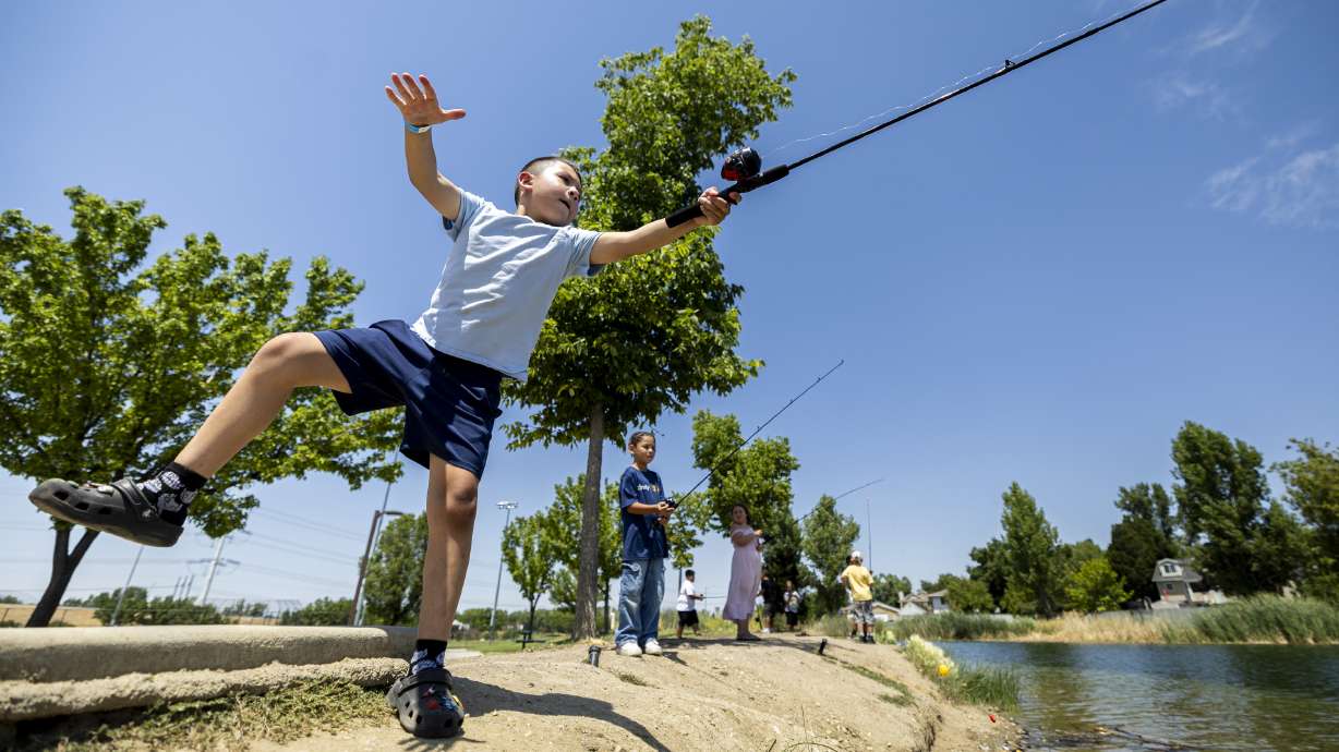 Alex, 8, maintains his balance as he casts his line while participants of the Boys & Girls Clubs of Greater Salt Lake fish with help from local Walmart store associates at Willow Pond in Murray on Wednesday.