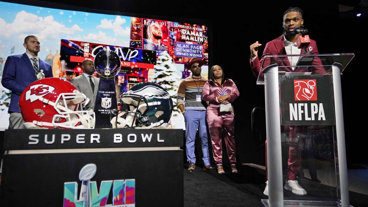 FILE - Buffalo Bills' Damar Hamlin speaks after being introduced as the winner of the Alan Page Community Award during a news conference ahead of the Super Bowl 57 NFL football game Feb. 8, 2023, in Phoenix. Damar's parents Mario and Nina Hamlin, center, look on with NFLPA President JC Tretter, left.