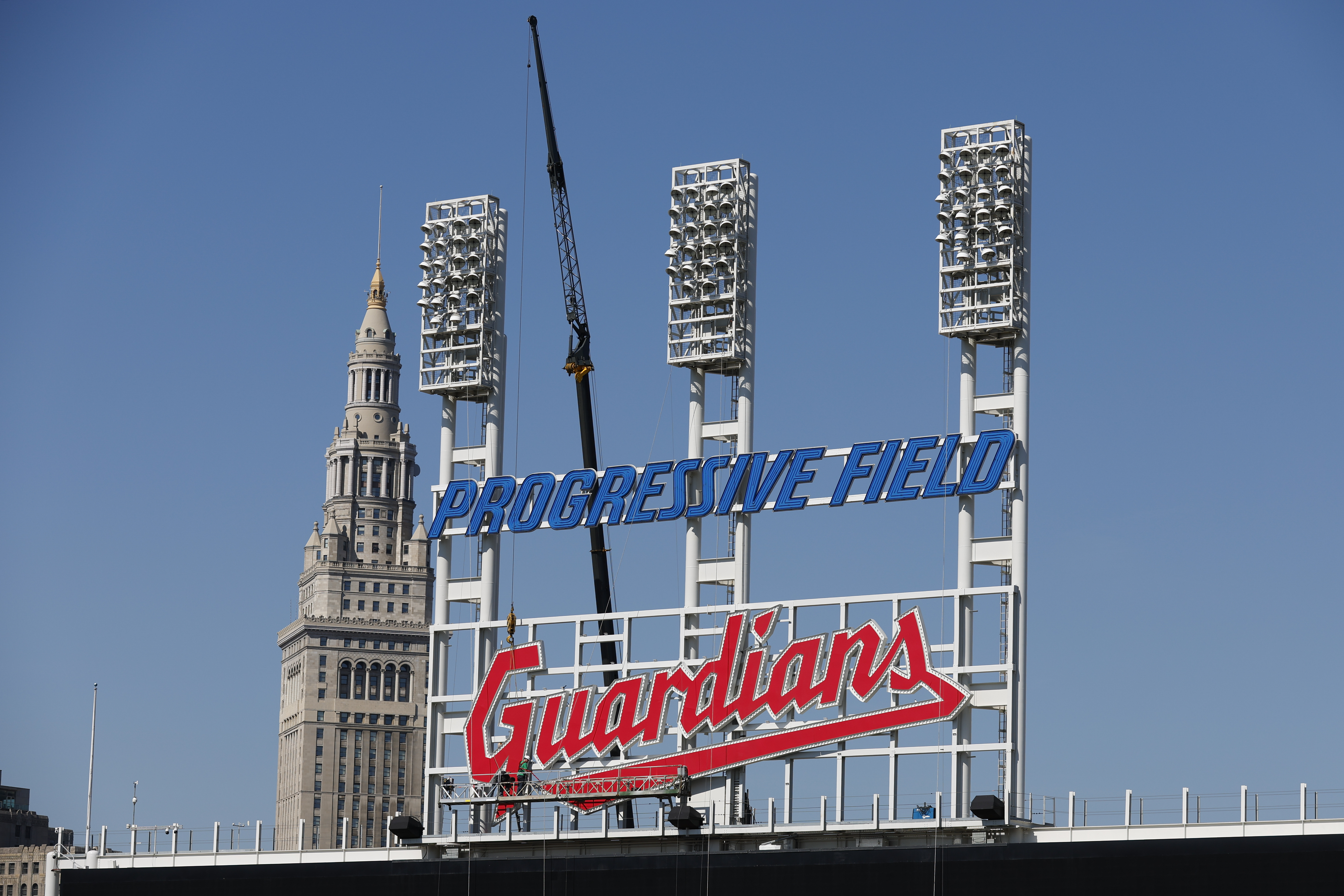 FILE - Workers finish installing the Cleveland Guardians sign above the scoreboard at Progressive Field, March 17, 2022, in Cleveland. 