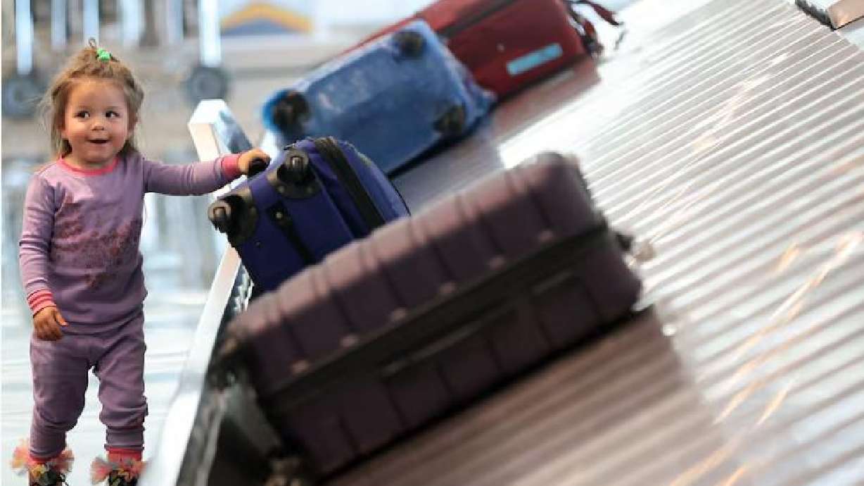 Rozlind Rindlesbach, 2, tries to help pull luggage off the carouse at Salt Lake City International Airport in Salt Lake City, Oct. 31, 2023. Homeland Security Secretary Kristi Noem announced the "Families on the Fly" campaign Friday.