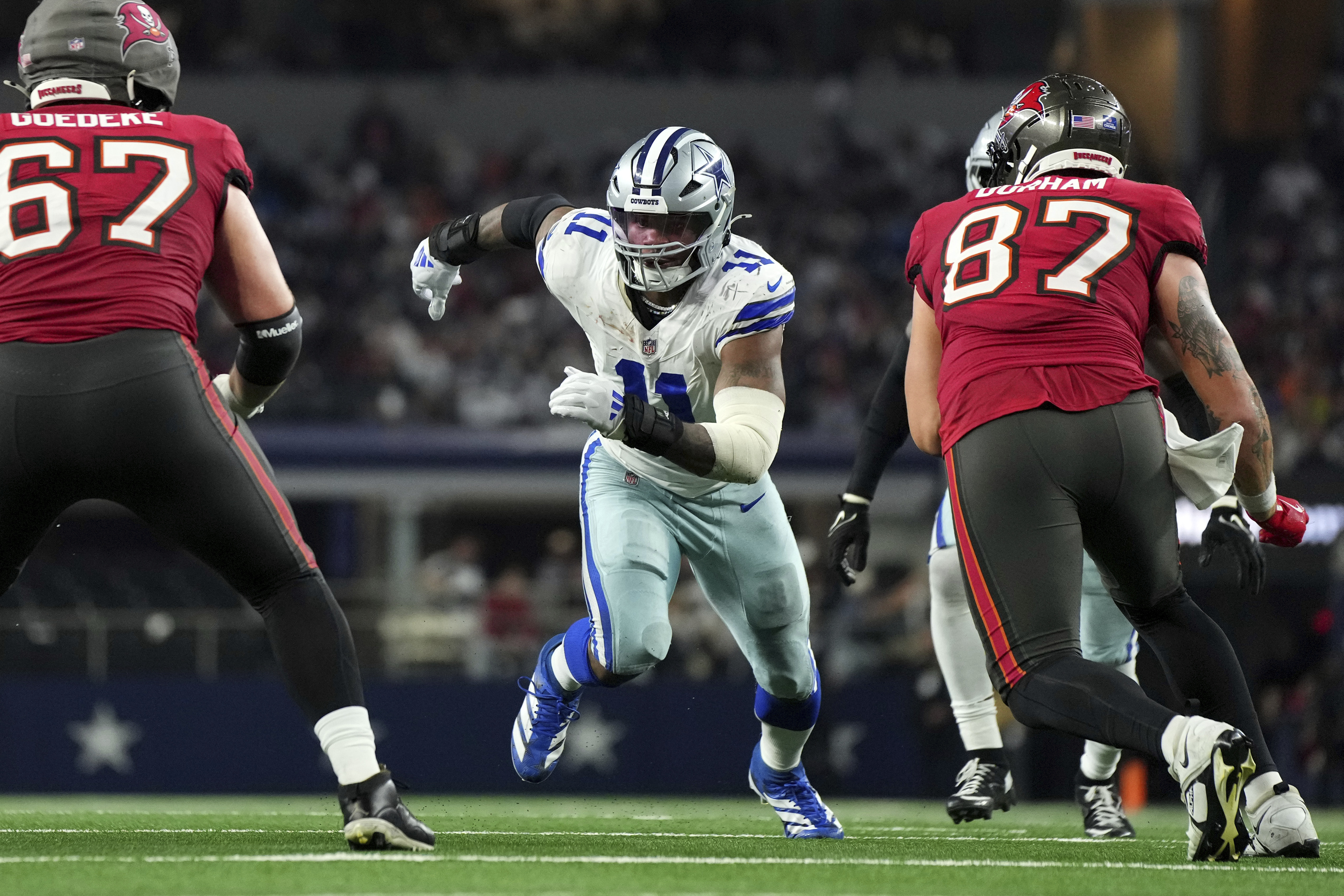 FILE - Dallas Cowboys linebacker Micah Parsons (11) rushes against Tampa Bay Buccaneers offensive tackle Luke Goedeke (67) and tight end Payne Durham (87) during the second half of a football game Sunday, Dec. 22, 2024, in Arlington, Texas. 