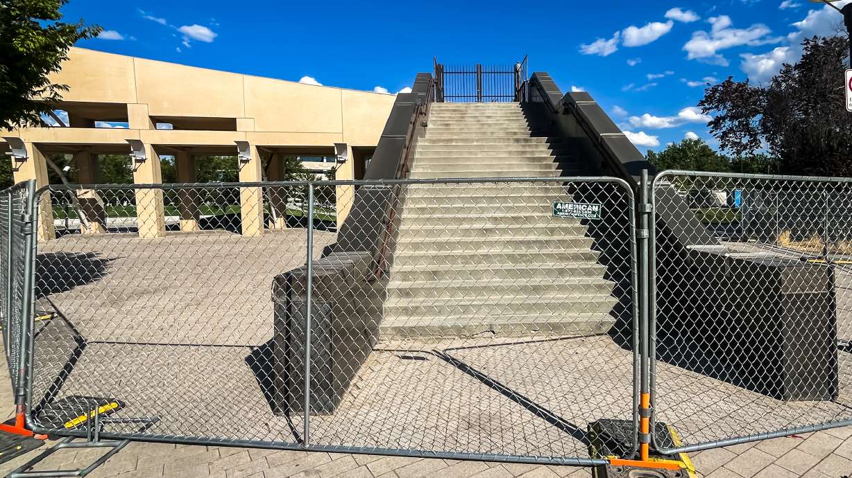 The entrance to the "Crescent Wall" stairway within the exterior of the Salt Lake City Main Library is fenced off for construction on Tuesday. Library officials said construction is now underway to repair the steps.
