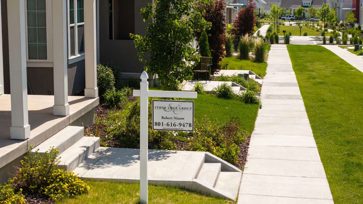 A real estate sign is posted near a home in West Jordan on June 3. Redfin says there's nearly $700 billion in unsold houses on the market nationwide, a record high.