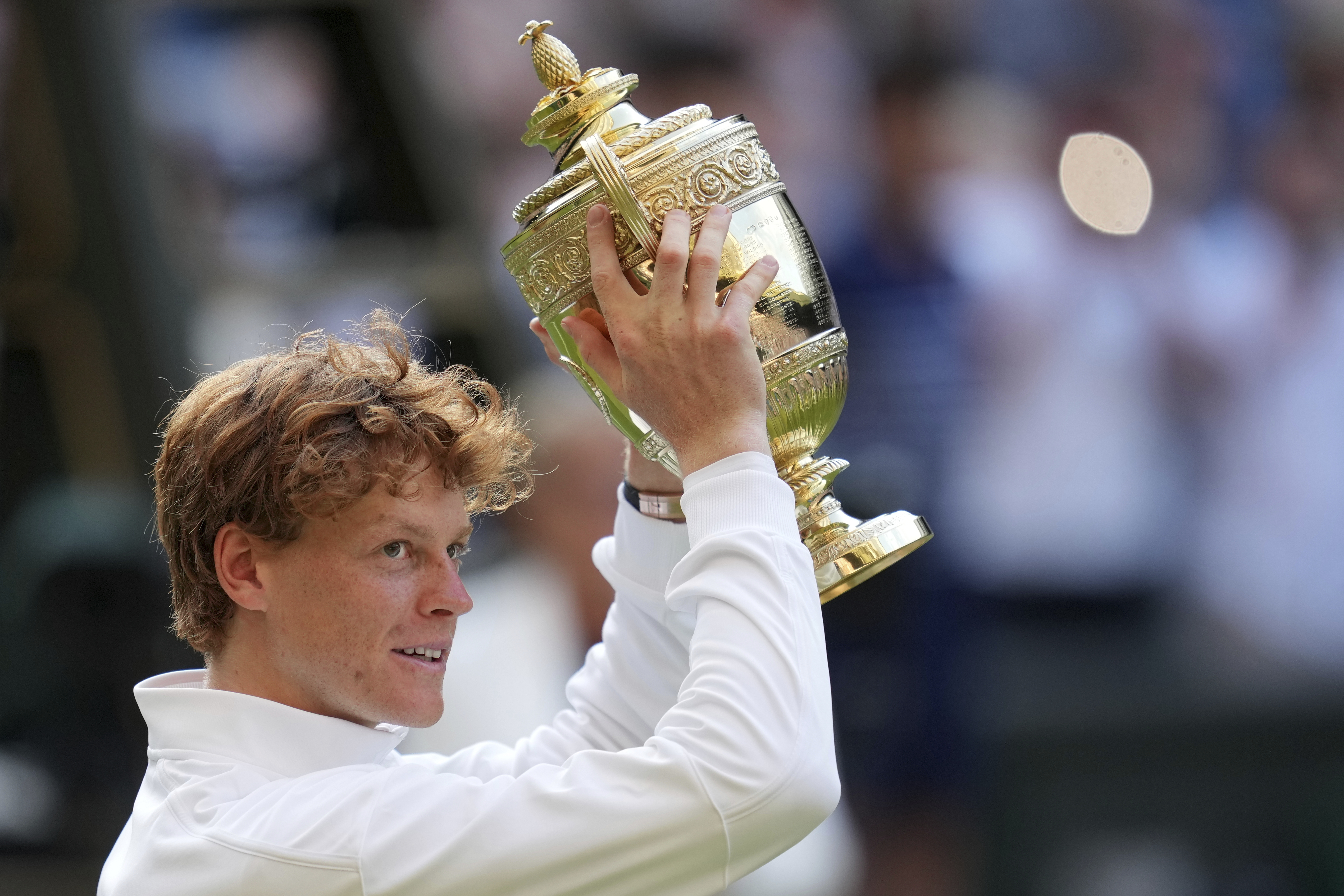 Italy's Jannik Sinner celebrates with the trophy after beating Carlos Alcaraz of Spain to win the men's singles final at the Wimbledon Tennis Championships in London, Sunday, July 13, 2025.