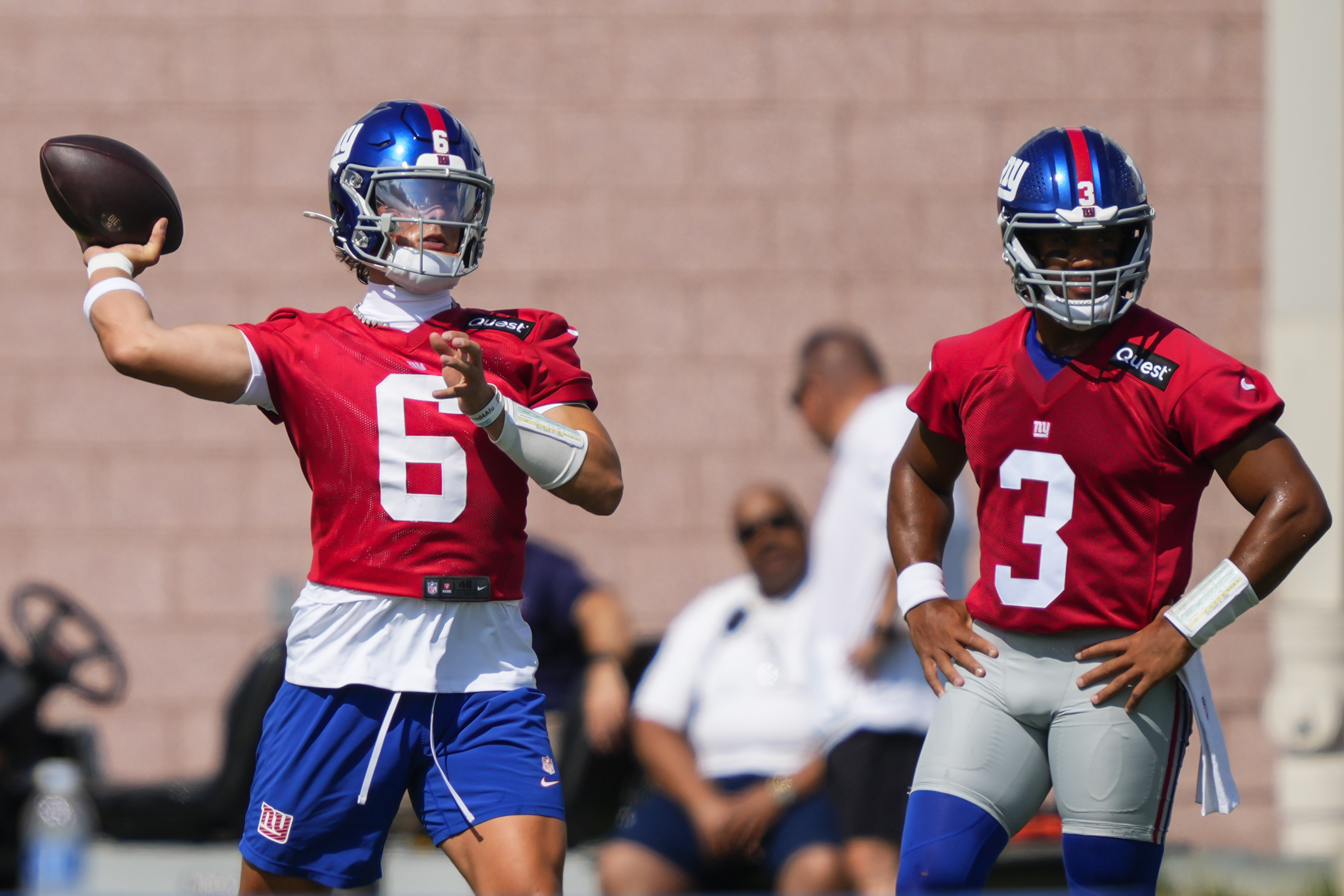 New York Giants quarterback Jaxson Dart (6) throws as quarterback Russell Wilson (3) watches during practice at the team's NFL football training camp in East Rutherford, N.J., Wednesday, July 23, 2025. 
