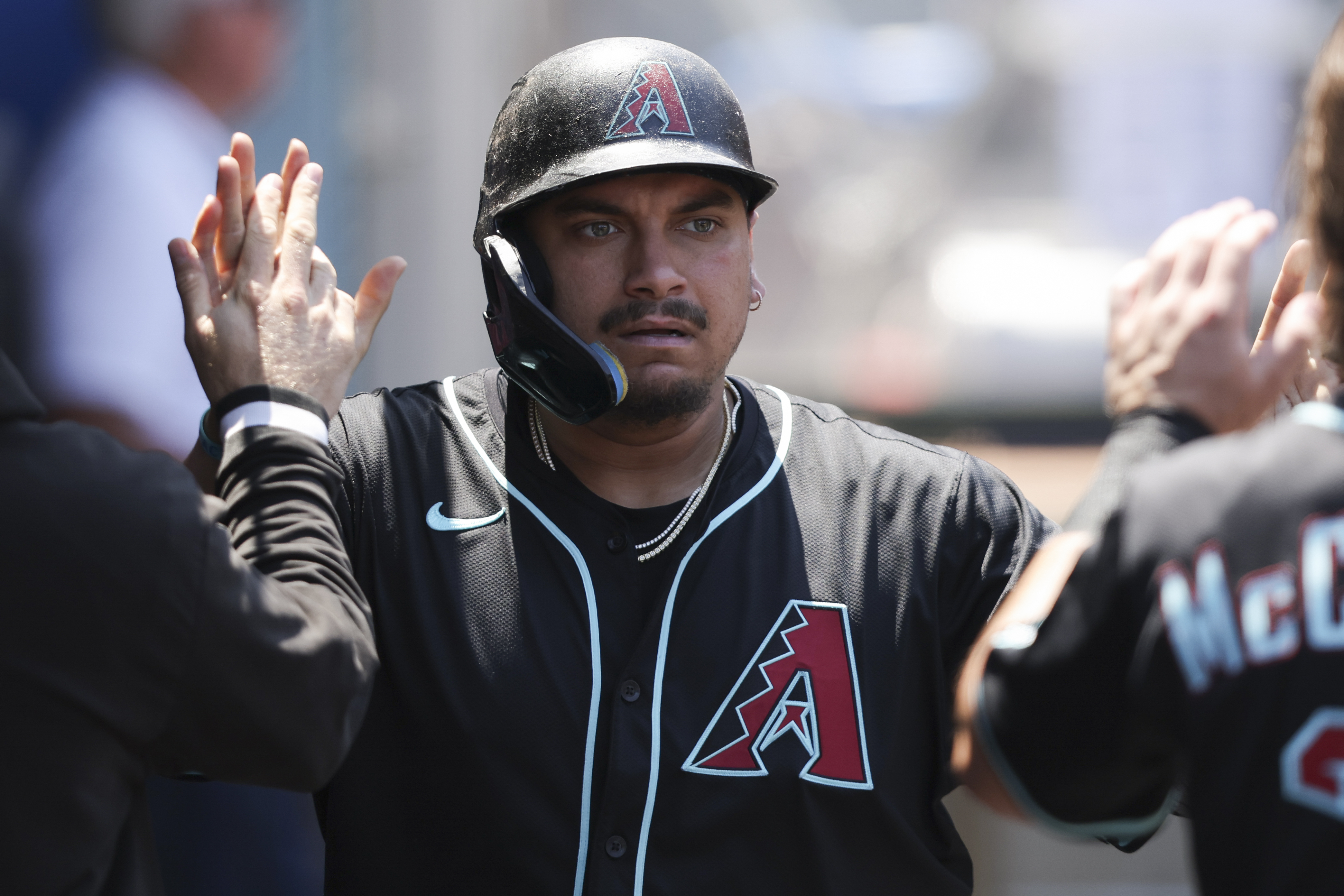 Arizona Diamondbacks' Josh Naylor celebrates in the dugout with his teammates after scoring during the fourth inning of a baseball game against the Los Angeles Angels in Anaheim, Calif., Sunday, July 13, 2025. 