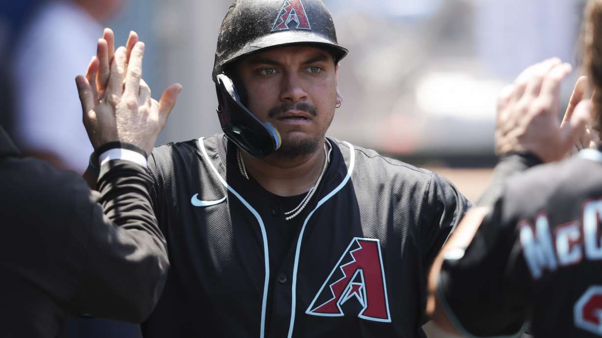 Arizona Diamondbacks' Josh Naylor celebrates in the dugout with his teammates after scoring during the fourth inning of a baseball game against the Los Angeles Angels in Anaheim, Calif., Sunday, July 13, 2025.
