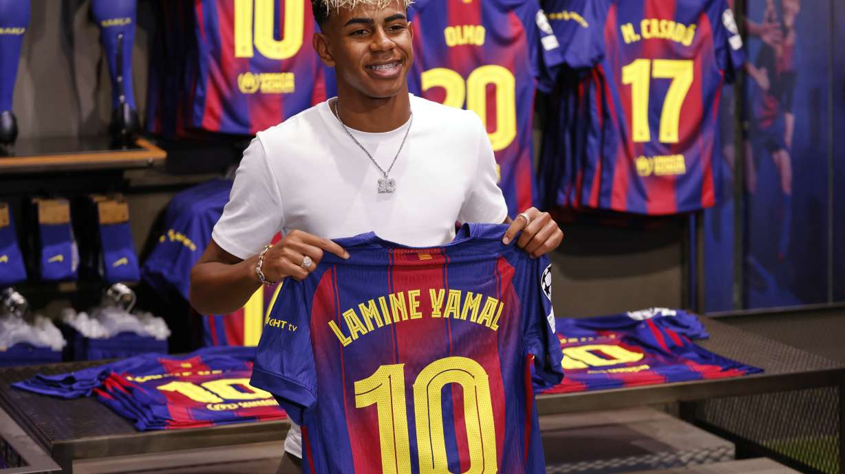 FC Barcelona player Lamine Yamal poses with his new jersey after signing a contract extension with the soccer club in Barcelona, northern Spain, Wednesday, July 16, 2025.