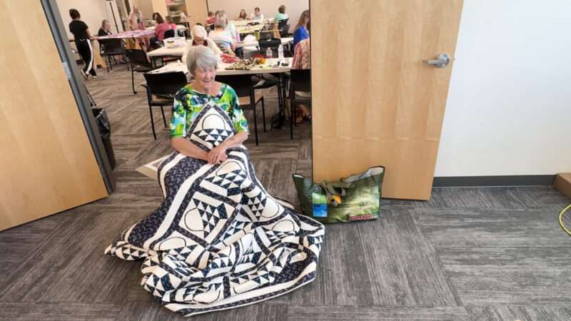 Quilter Virginia Lee displays a quilt in Salt Lake City. She says quilting became a type of therapy for her.