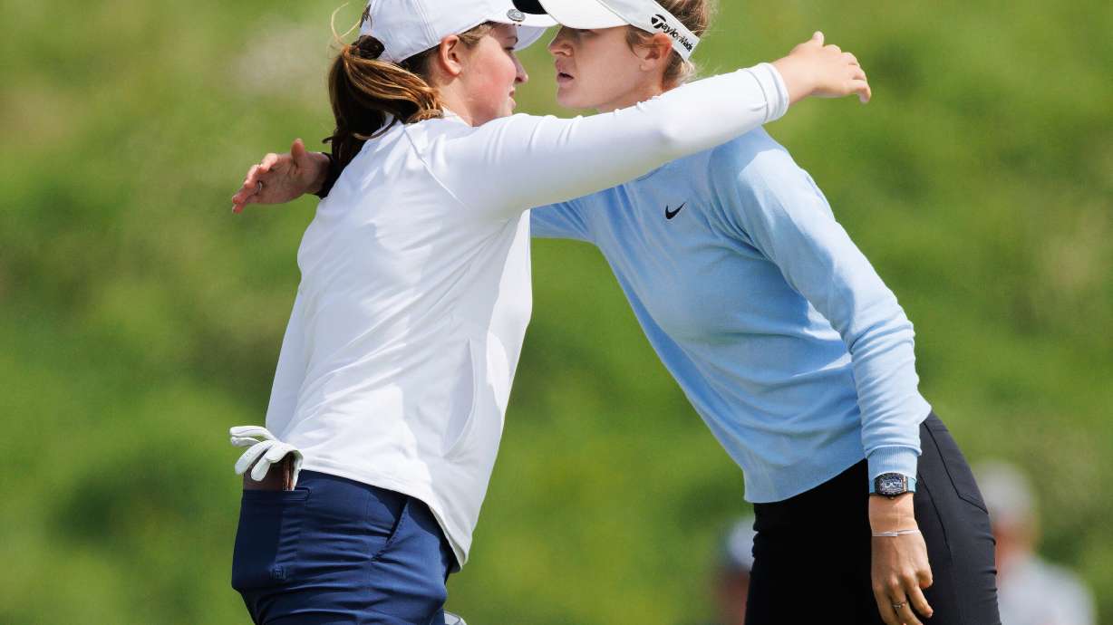 Lottie Woad, left, and Nelly Korda embrace after completing the first round of the women's Scottish Open golf tournament, Thursday, July 24, 2025, at Dundonald Links in Irvine, Scotland.