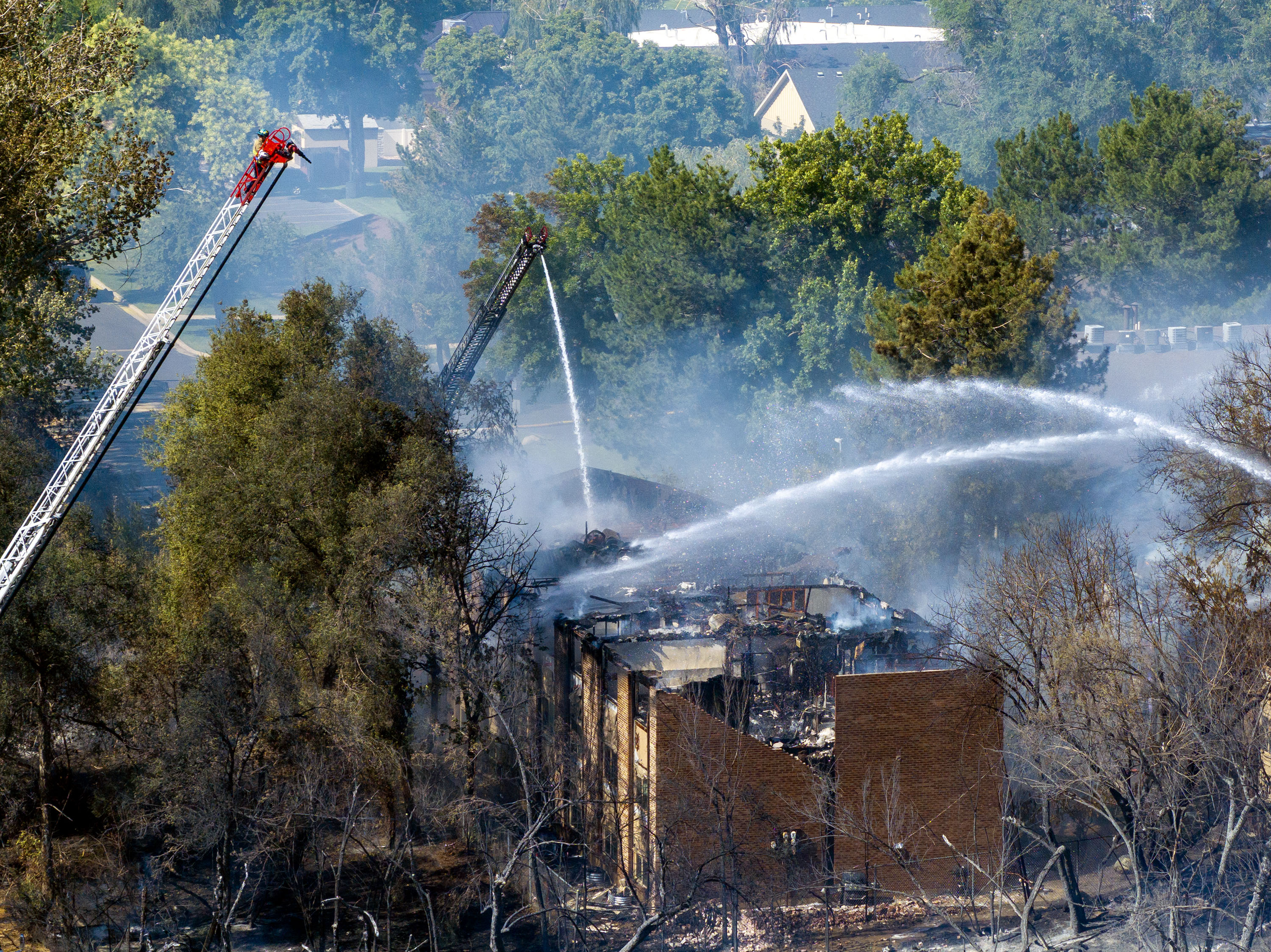 Firefighters work to douse a fire burning near 4600 South and 1300 East in Millcreek on Friday. The fire destroyed two apartment buildings, displacing residents of 24 units.