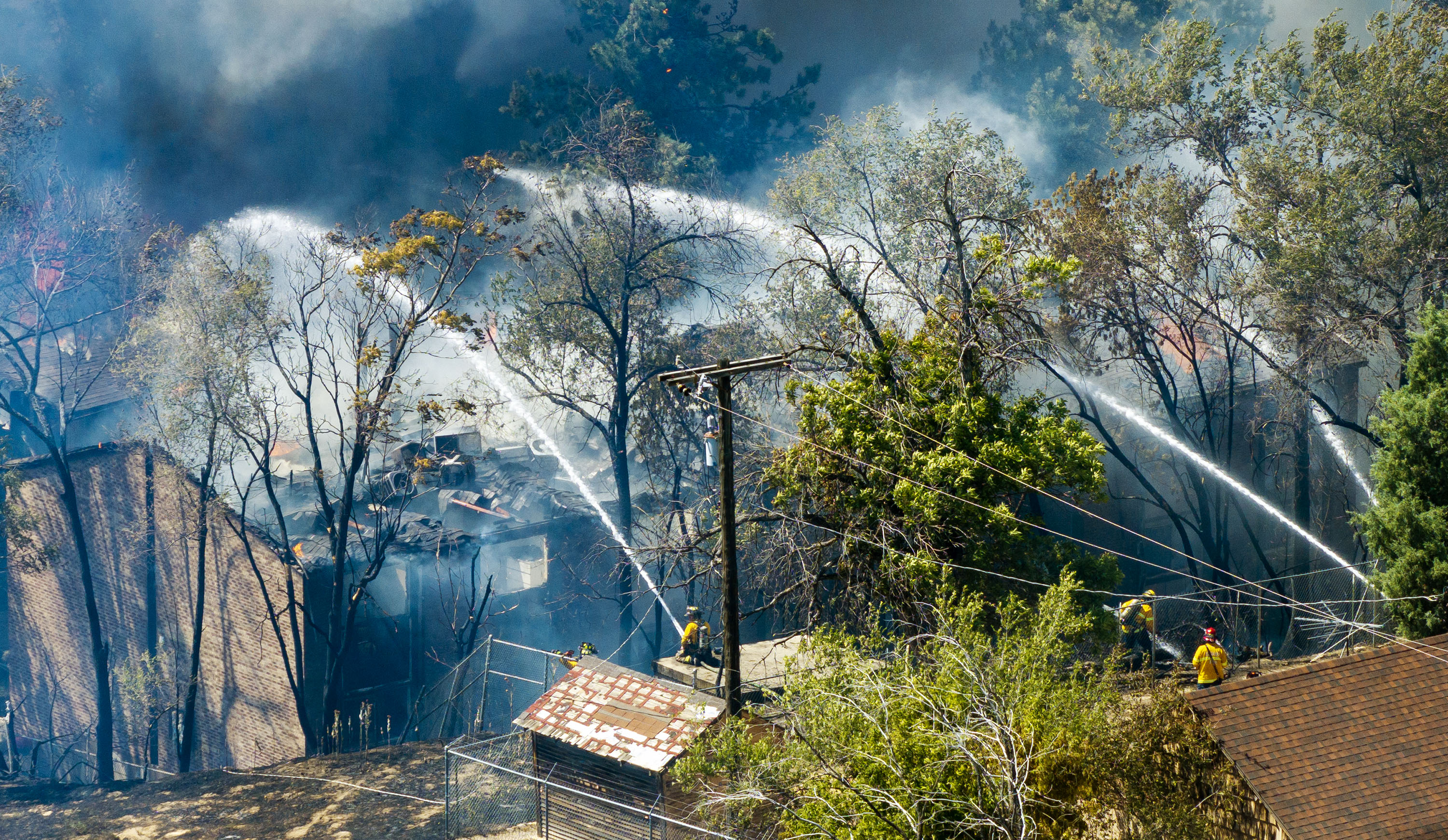 Fire and police respond to a large fire in the Millcreek area on Friday. Salt Lake City's mayor is now calling for a review of conditions at every property the city owns following the fire that destroyed two apartment buildings.