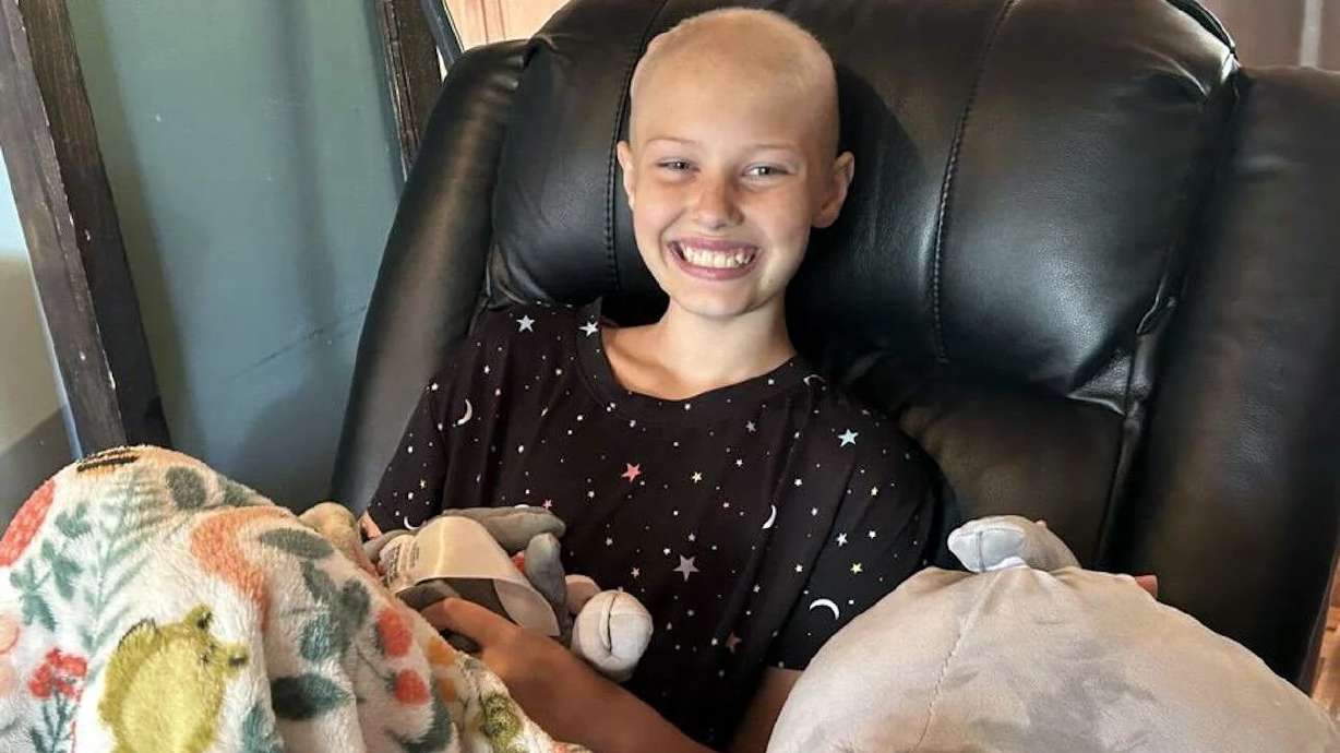 Brooklynn Shorter, 12, smiles while holding one of her plush Eeyore toys in the living room of her home in Cedar City, July 10.