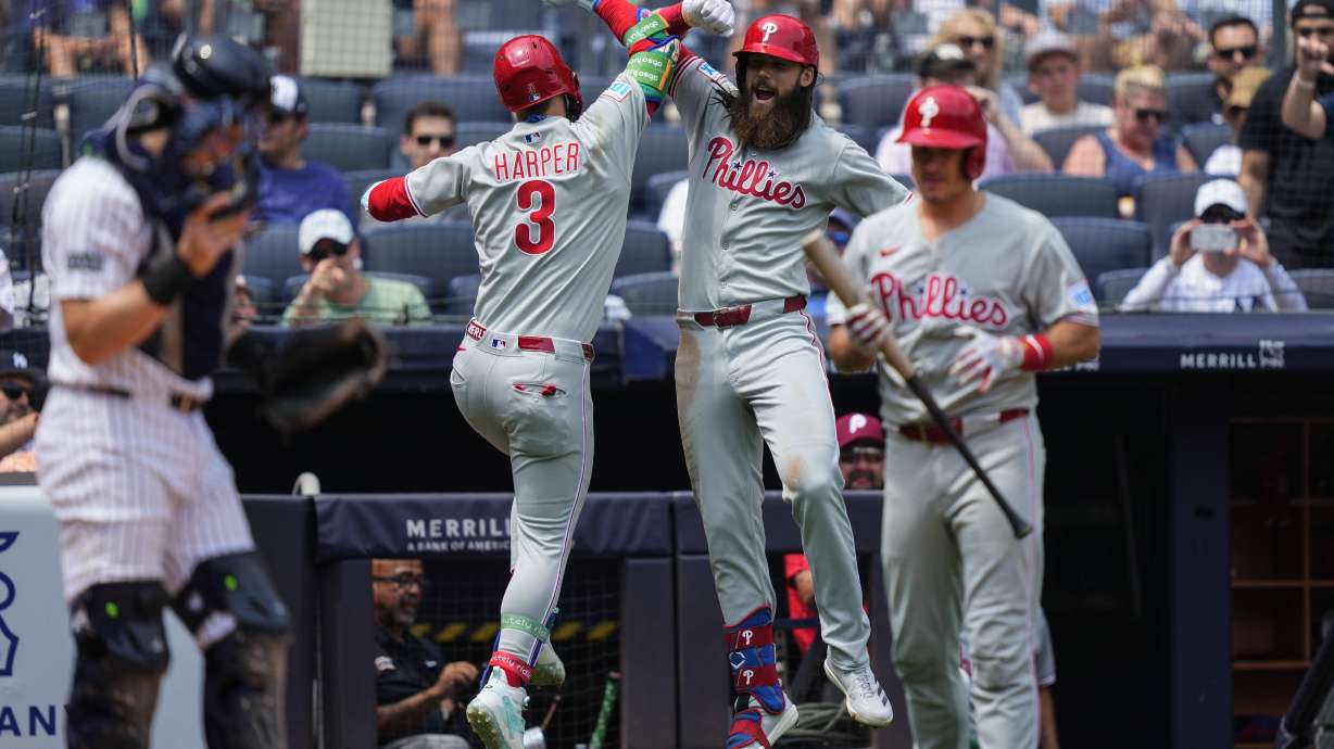 Philadelphia Phillies' Bryce Harper (3) and' Brandon Marsh (16) celebrate after Harper hit a home run during the third inning of a baseball game against the New York Yankees, Saturday, July 26, 2025, in New York.