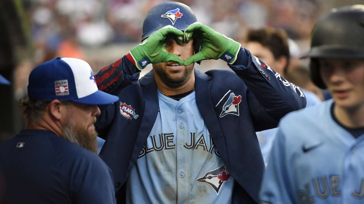 Toronto Blue Jays' George Springer, center, reacts after hitting a home run during the ninth inning of a baseball game against the Detroit Tigers, Saturday, July 26, 2025, in Detroit.