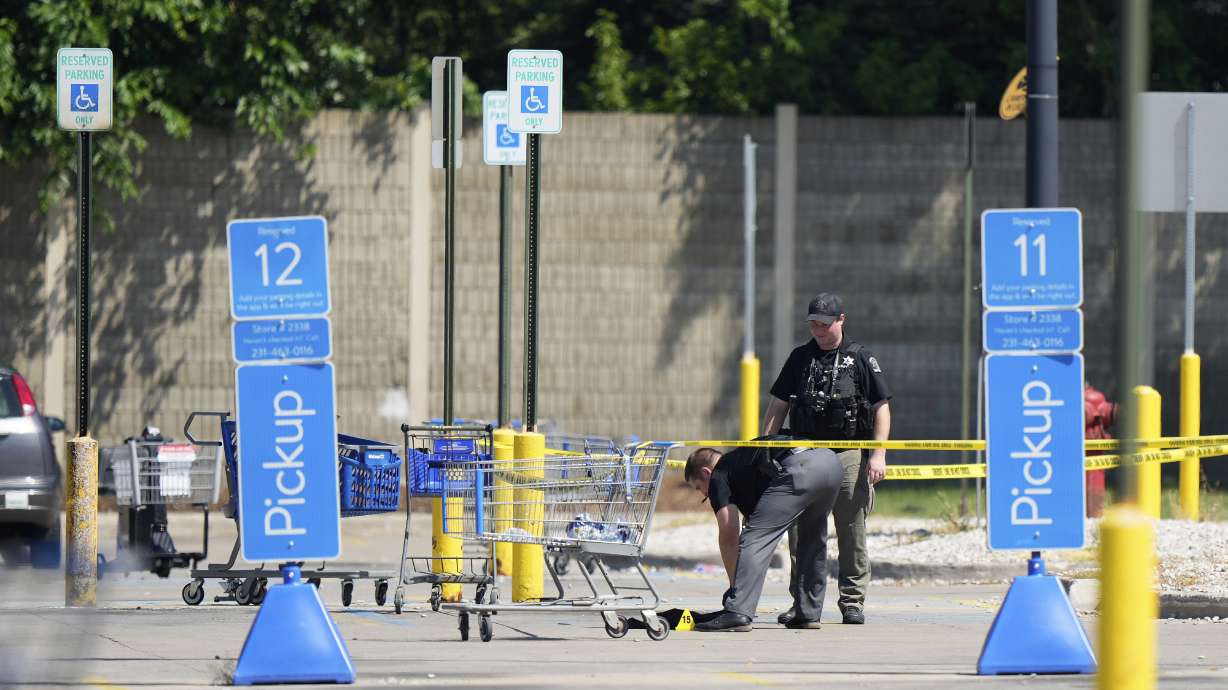 Officers investigate Sunday the scene where 11 people were stabbed at a Walmart in Traverse City, Mich. A Michigan prosecutor filed a terrorism charge Monday.
