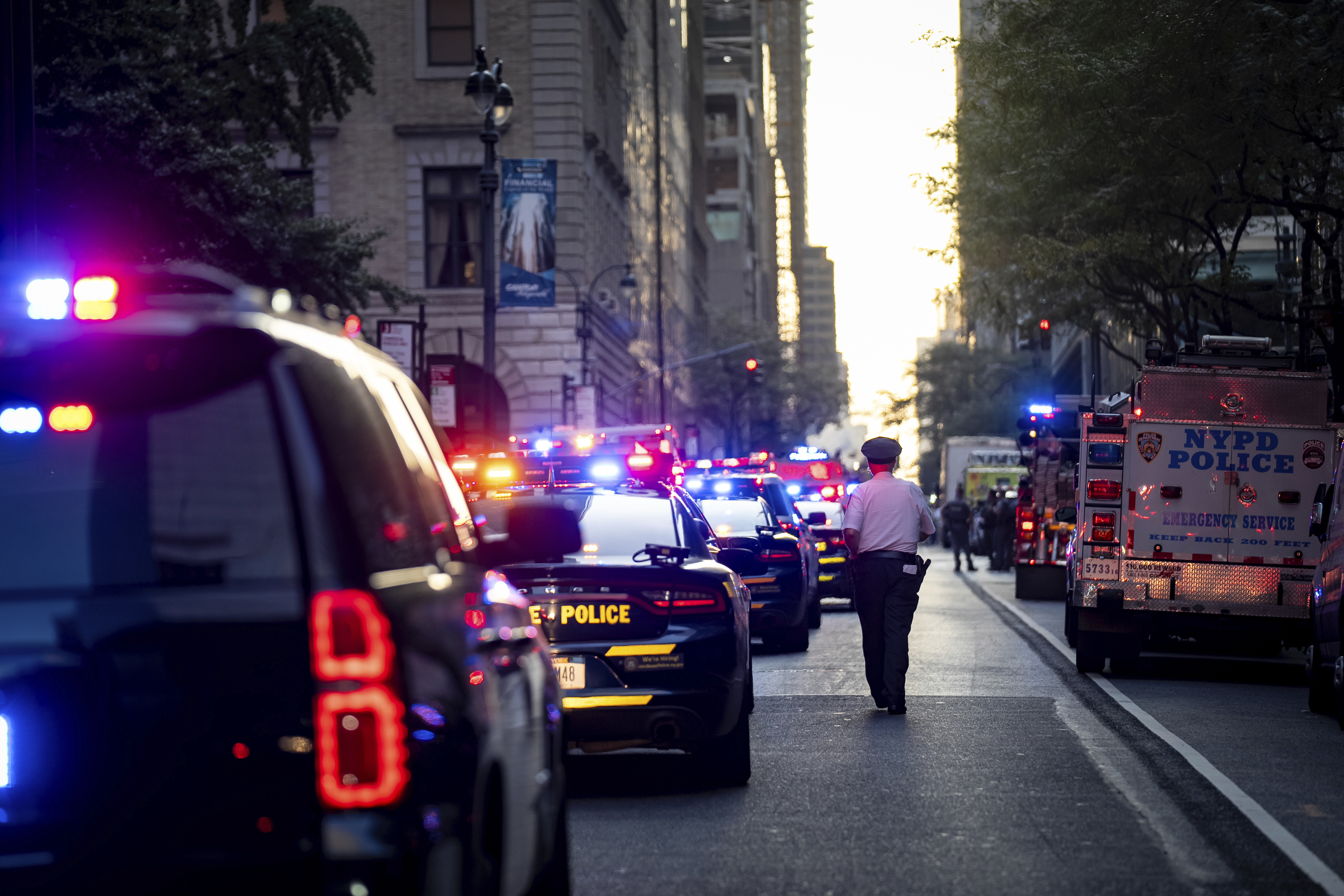 A New York police officer stands watch on 52nd Street outside a Manhattan office building where at least two people were shot, including a police officer, Monday, July 28, 2025, in New York. 