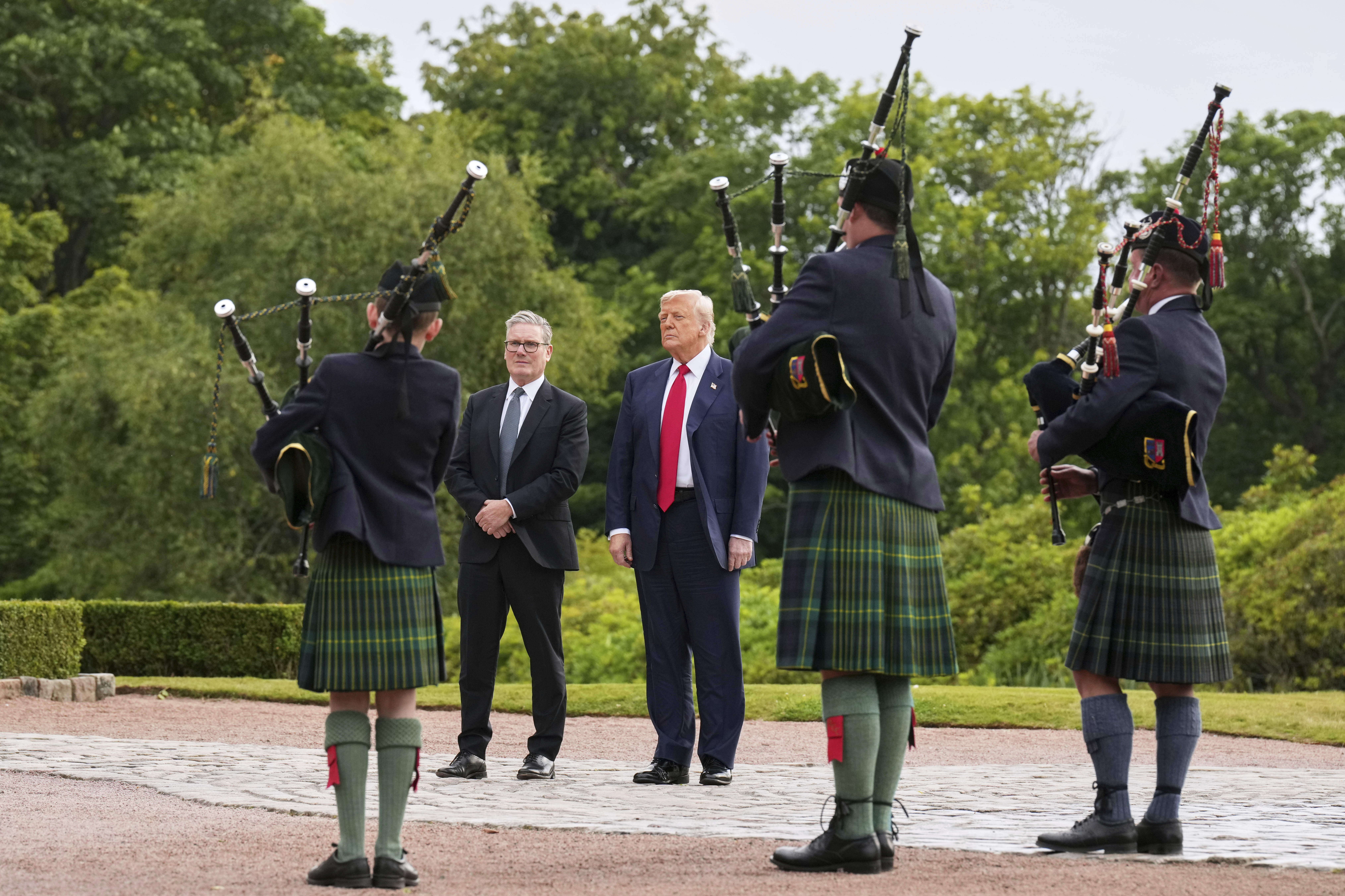 President Donald Trump, third right, and Britain's Prime Minister Keir Starmer, fourth right, are welcomed at Trump International Golf Links, near Aberdeen, Scotland, Monday, July 28, 2025.