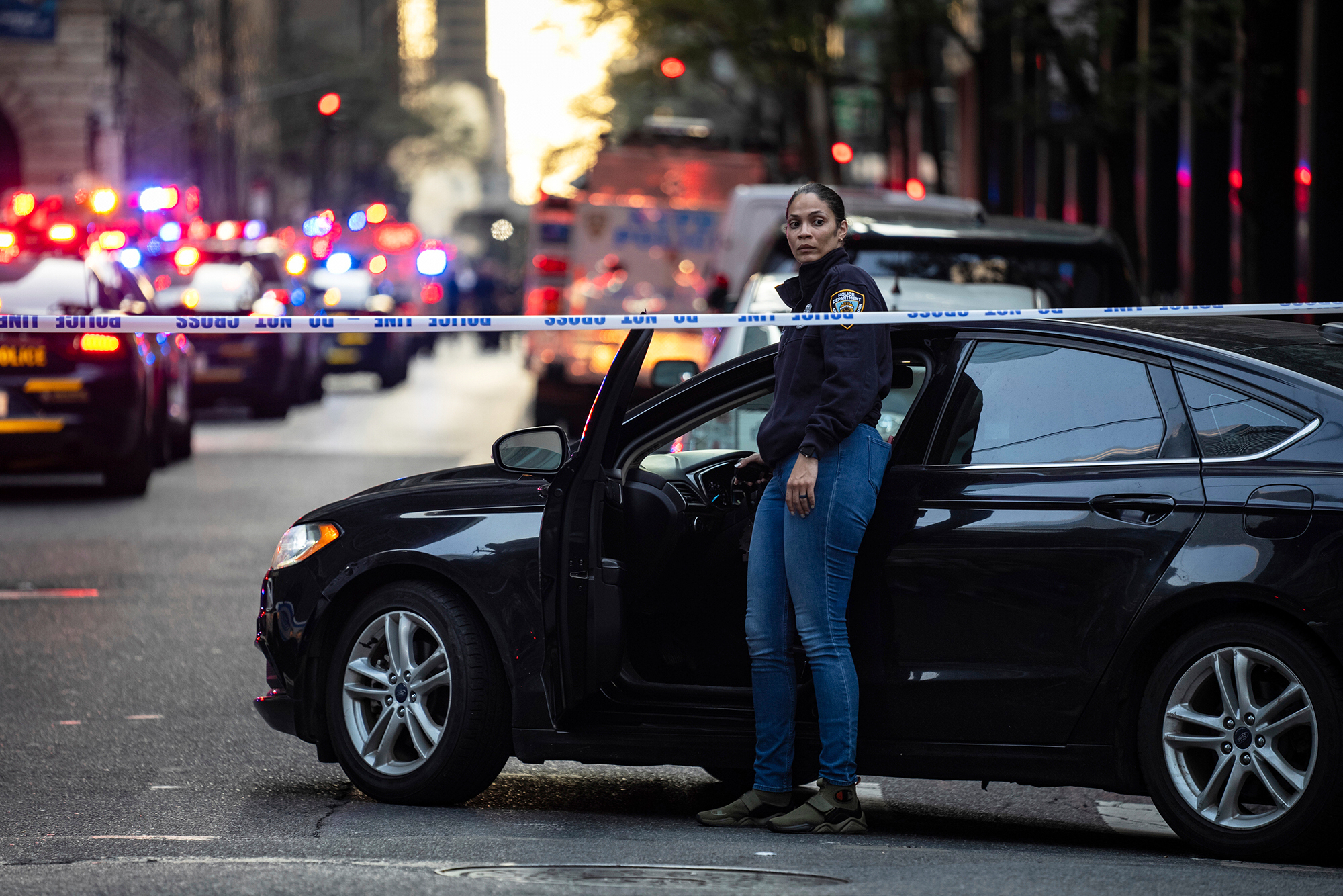A New York police investigator exits her vehicle at the scene outside a Manhattan office building where two people were shot including a police officer, Monday, July 28, 2025, in New York.
