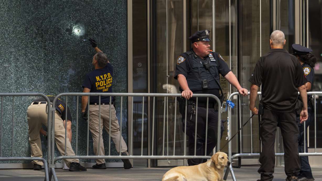 Members of the NYPD Crime Unit examine a door, Tuesday, in New York. A gunman who killed four people in a Manhattan office building Monday was trying to get to the office of the National Football League and claimed to have CTE, police said.