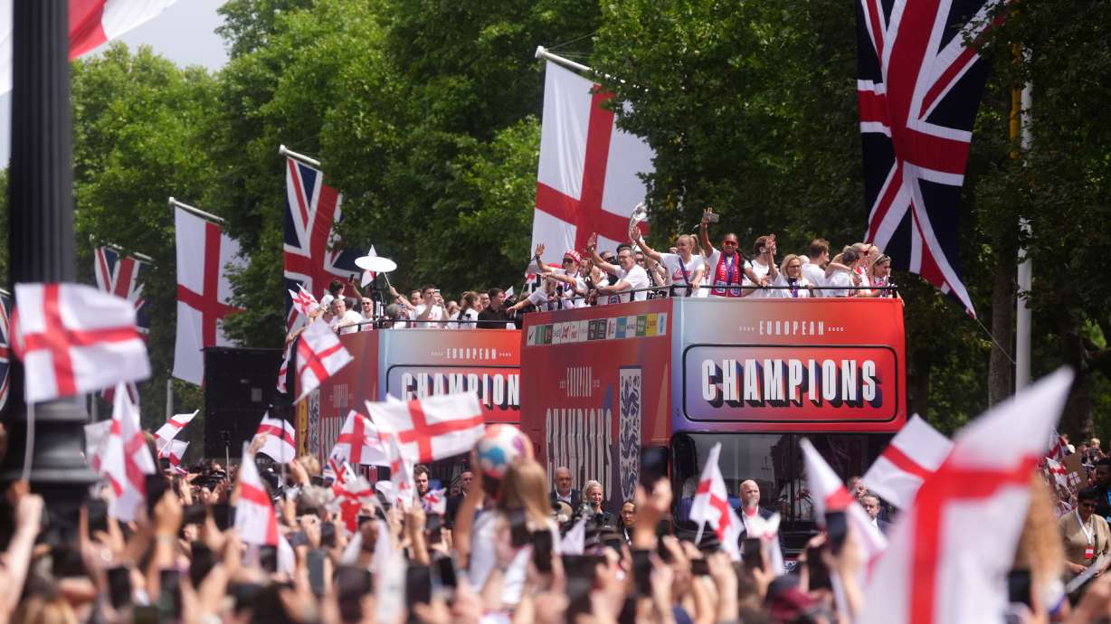 Buses carrying England players and staff make their way down the Mall during a Homecoming Victory Parade in London, Tuesday July 29, 2025, two days after England defended their European Championship crown as they beat Spain on penalties in the final of Euro 2025.