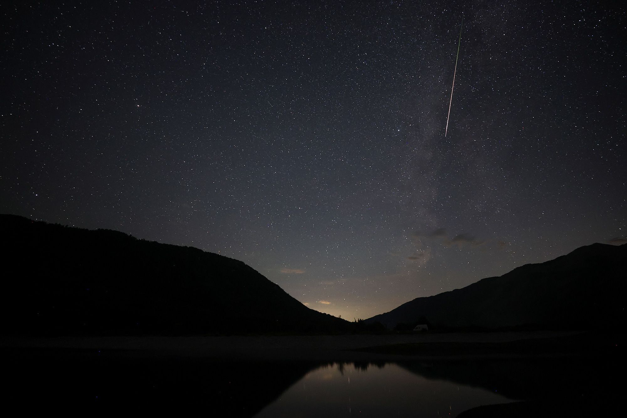 A ray of light sits under the night sky. Sky-gazers may be able to see the Perseid meteor shower alongside the Aquariids and Capricornids meteor showers this week.