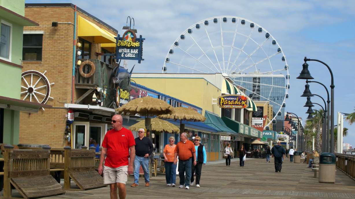 Visitors walk along the boardwalk in downtown Myrtle Beach, S.C., March 7, 2012. South Carolina and North Carolina have the most interest from movers in 2025, according to a recent report.