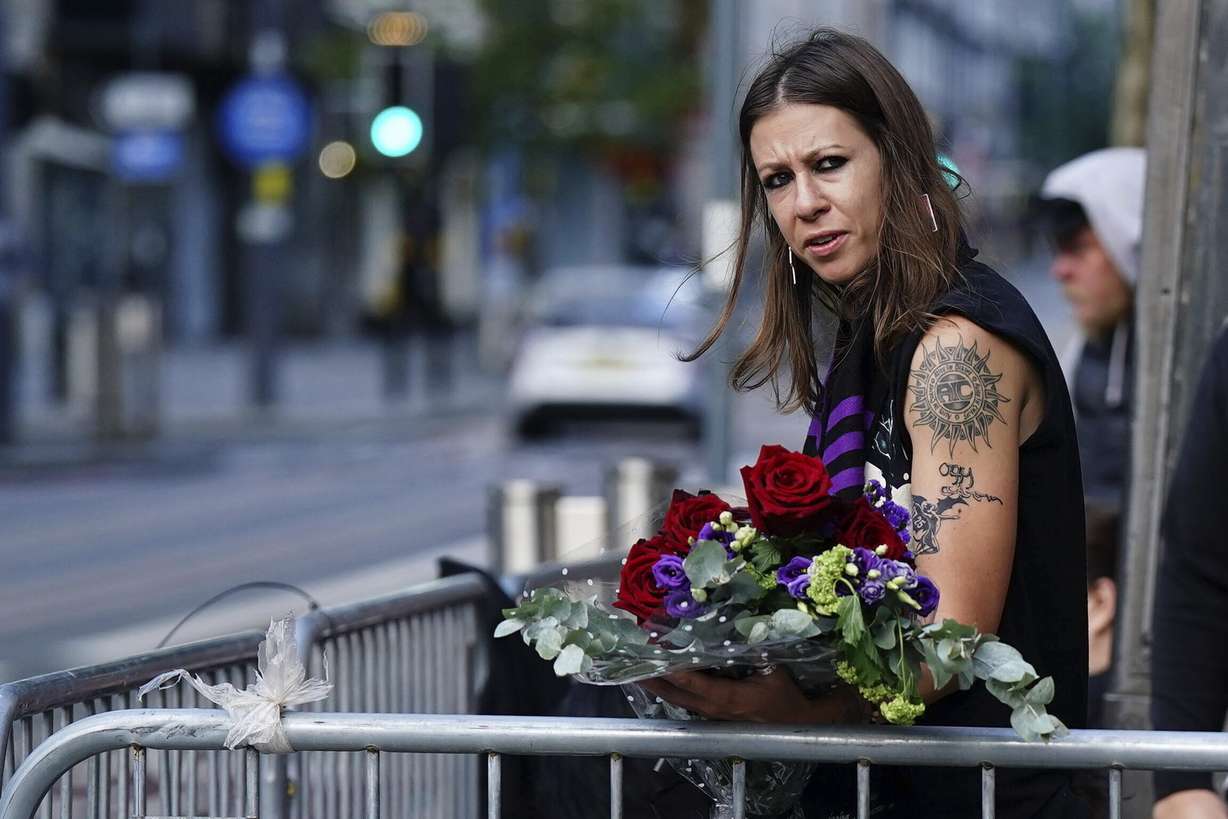 A fan waits near the Black Sabbath Bridge bench on Broad Street ahead of the funeral procession for Black Sabbath frontman Ozzy Osbourne, in Birmingham, England, Wednesday.