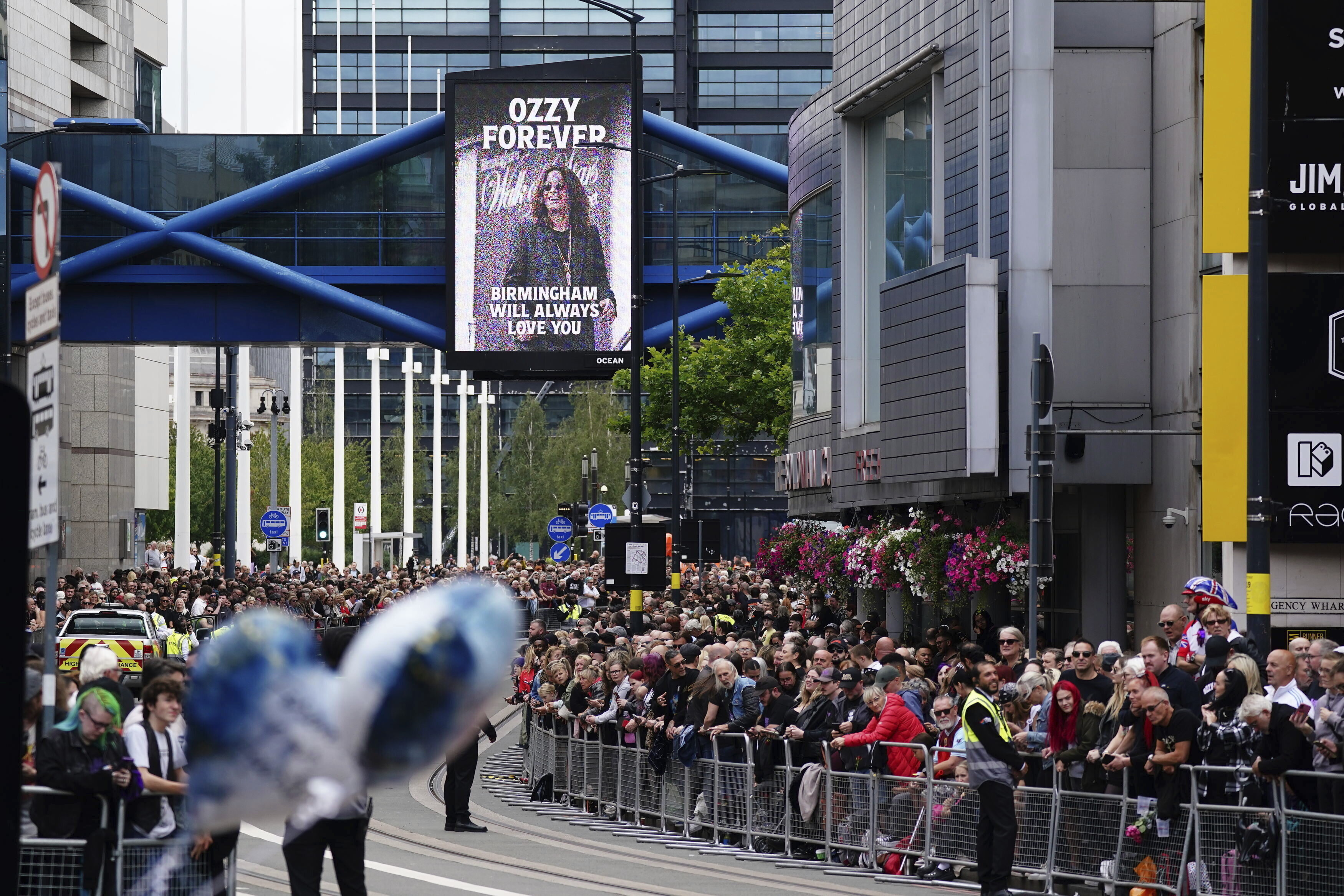 Fans gather Broad Street ahead of the funeral procession for Black Sabbath frontman Ozzy Osbourne following his death, in Birmingham, England, Wednesday.