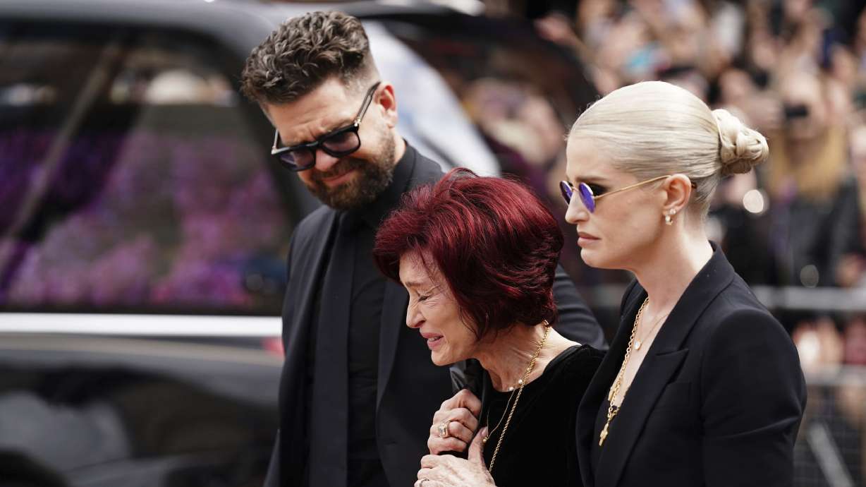 Jack Osbourne, Sharon Osbourne and Kelly Osbourne at the Black Sabbath Bridge bench on Broad Street in Birmingham, England, Wednesday, as the Osbournes and music fans paid their respects to Ozzy Osbourne, who passed away July 22.