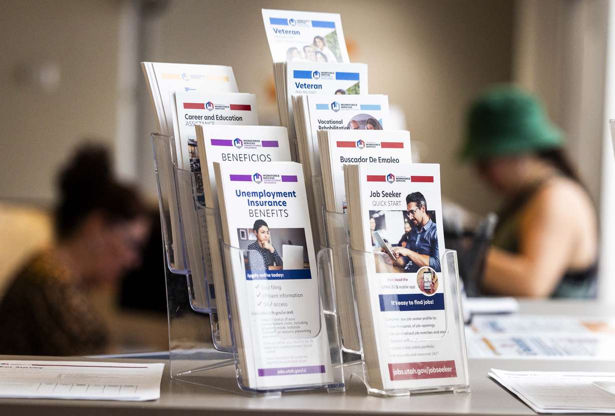 Pamphlets are pictured while a person talks with a worker at the Utah Department of Workforce Services in Taylorsville on July 3.