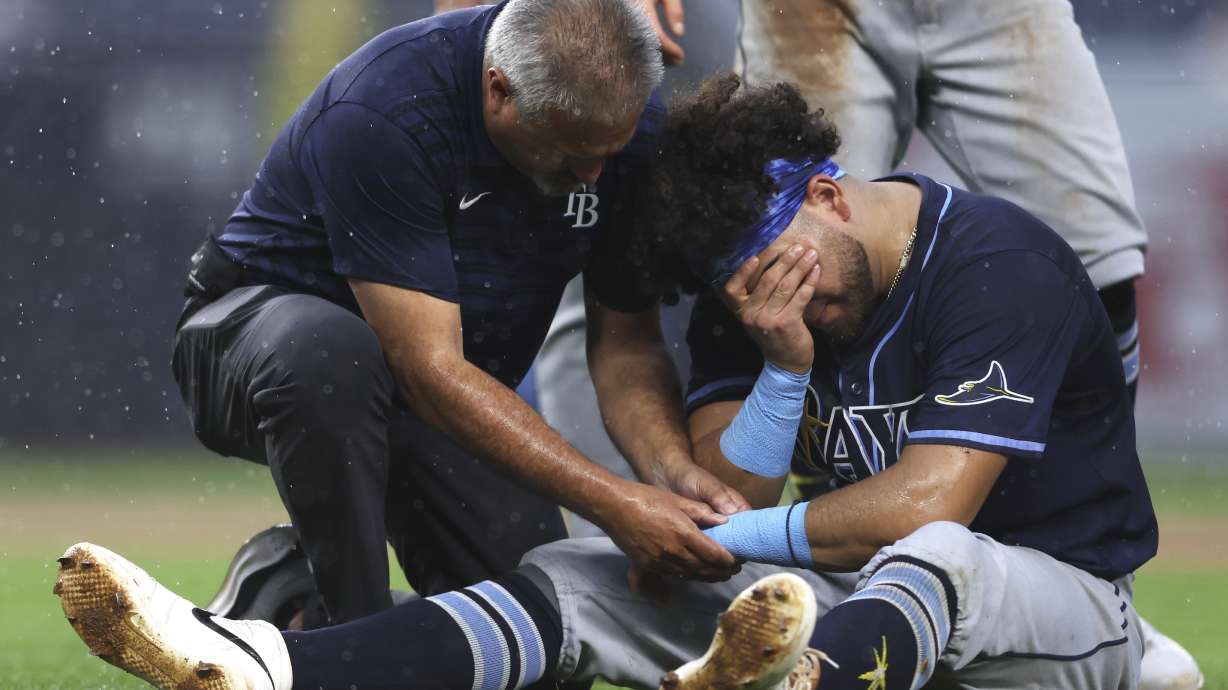 Tampa Bay Rays' Jonathan Aranda (62) is tended to after he was injured in the fifth inning of a baseball game against the New York Yankees, Thursday, July 31, 2025, in New York.