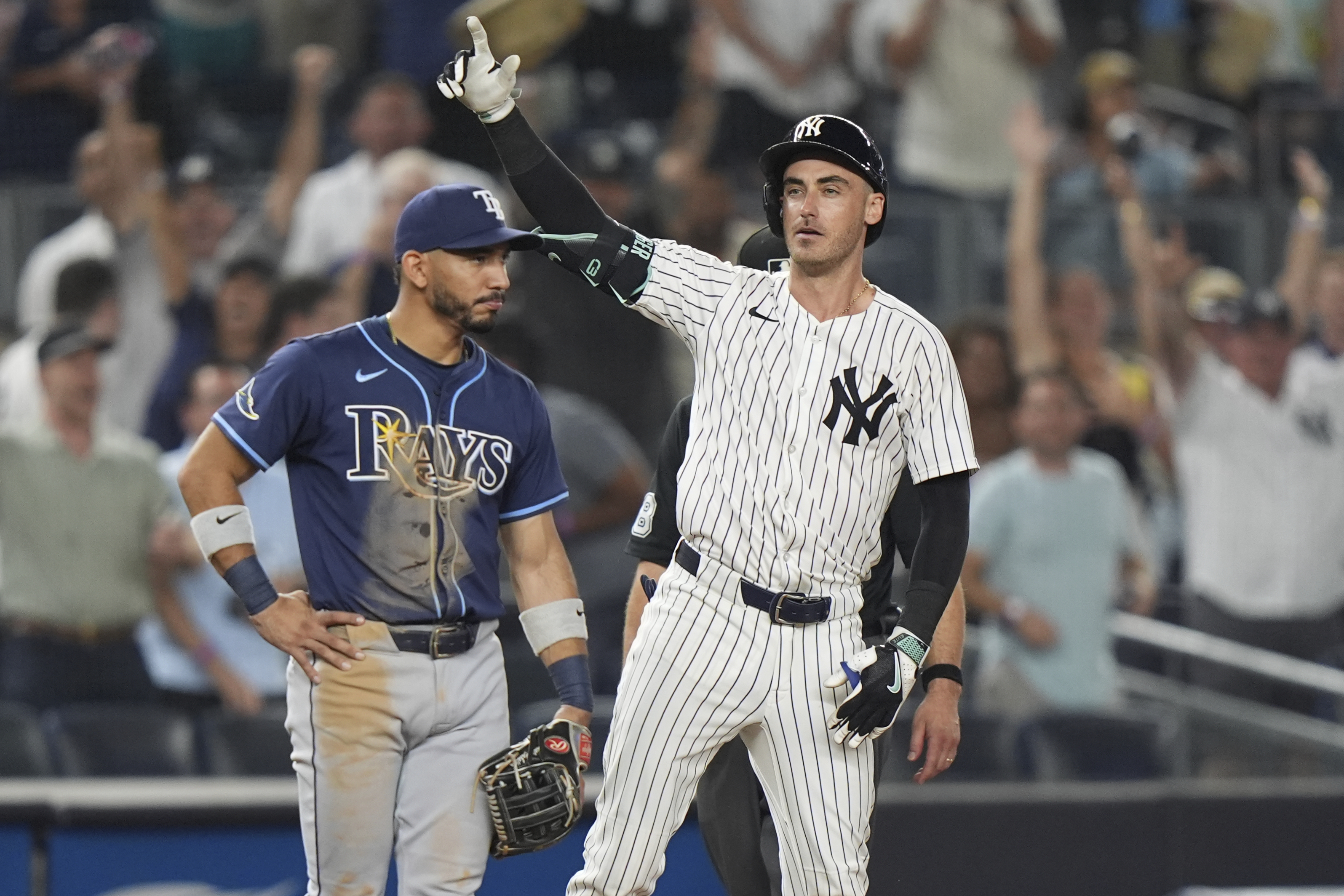 Tampa Bay Rays shortstop José Caballero watches as New York Yankees' Cody Bellinger gestures to teammates after hitting an RBI triple during the 10th inning of a baseball game Wednesday, July 30, 2025, in New York. 