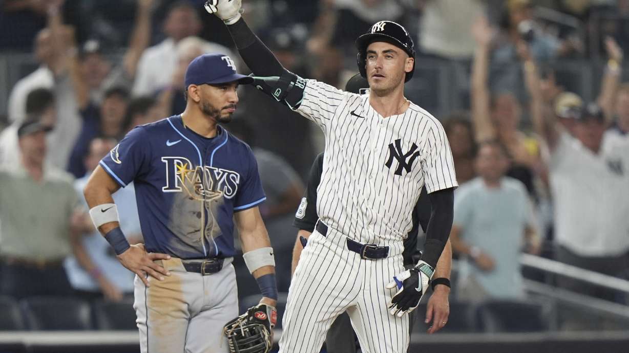 Tampa Bay Rays shortstop José Caballero watches as New York Yankees' Cody Bellinger gestures to teammates after hitting an RBI triple during the 10th inning of a baseball game Wednesday, July 30, 2025, in New York.