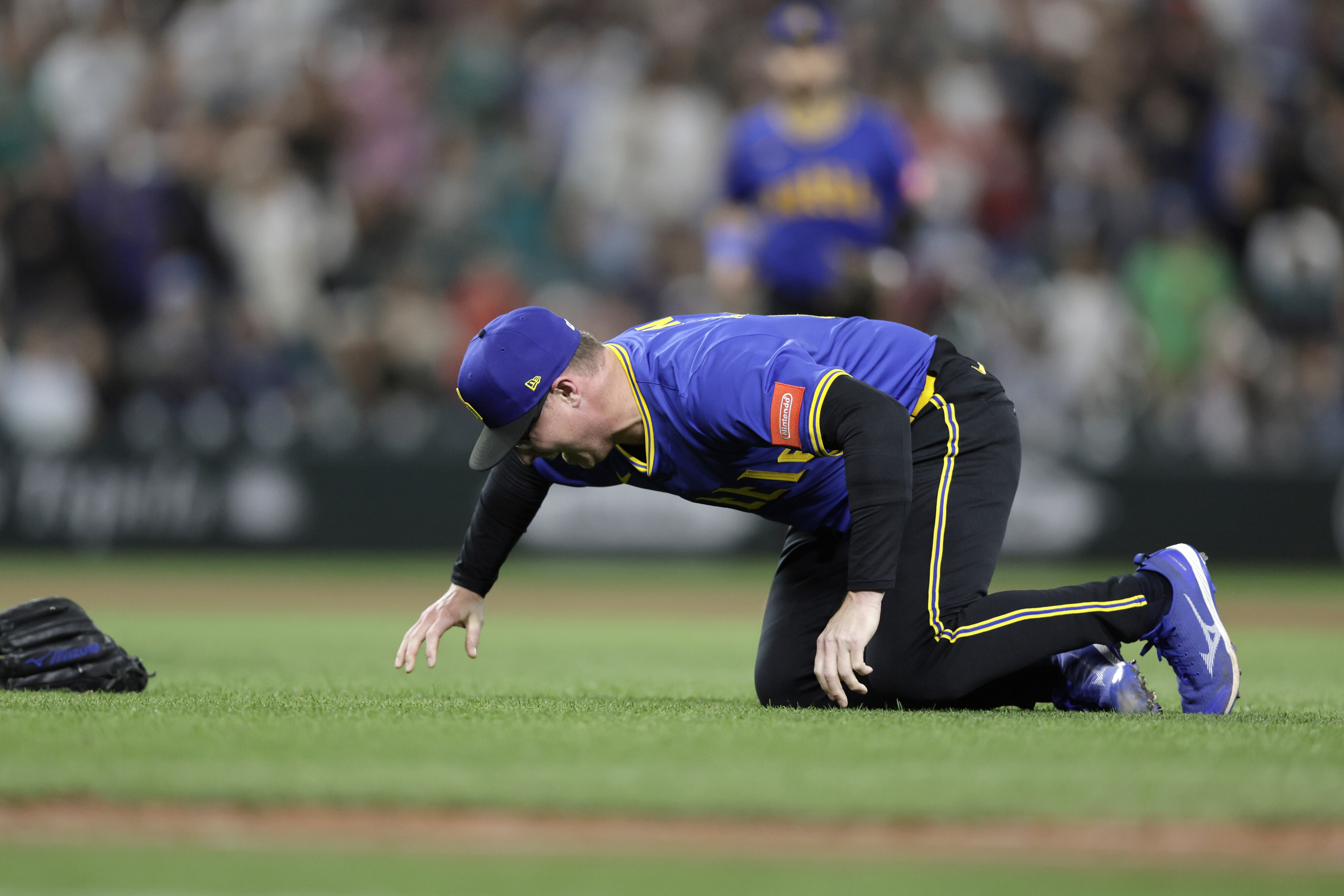 Seattle Mariners pitcher Trent Thornton goes to the ground with an injury during the ninth inning against the Texas Rangers in a baseball game Thursday, July 31, 2025, in Seattle. 