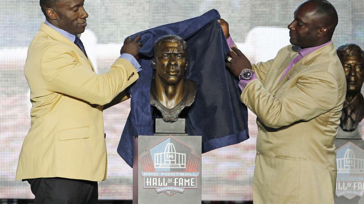FILE - Shannon Sharpe, left, unveils a bust of himself along with his presenter and brother, Sterling Sharpe, during the induction ceremony at the Pro Football Hall of Fame, Saturday, Aug. 6, 2011, in Canton, Ohio.