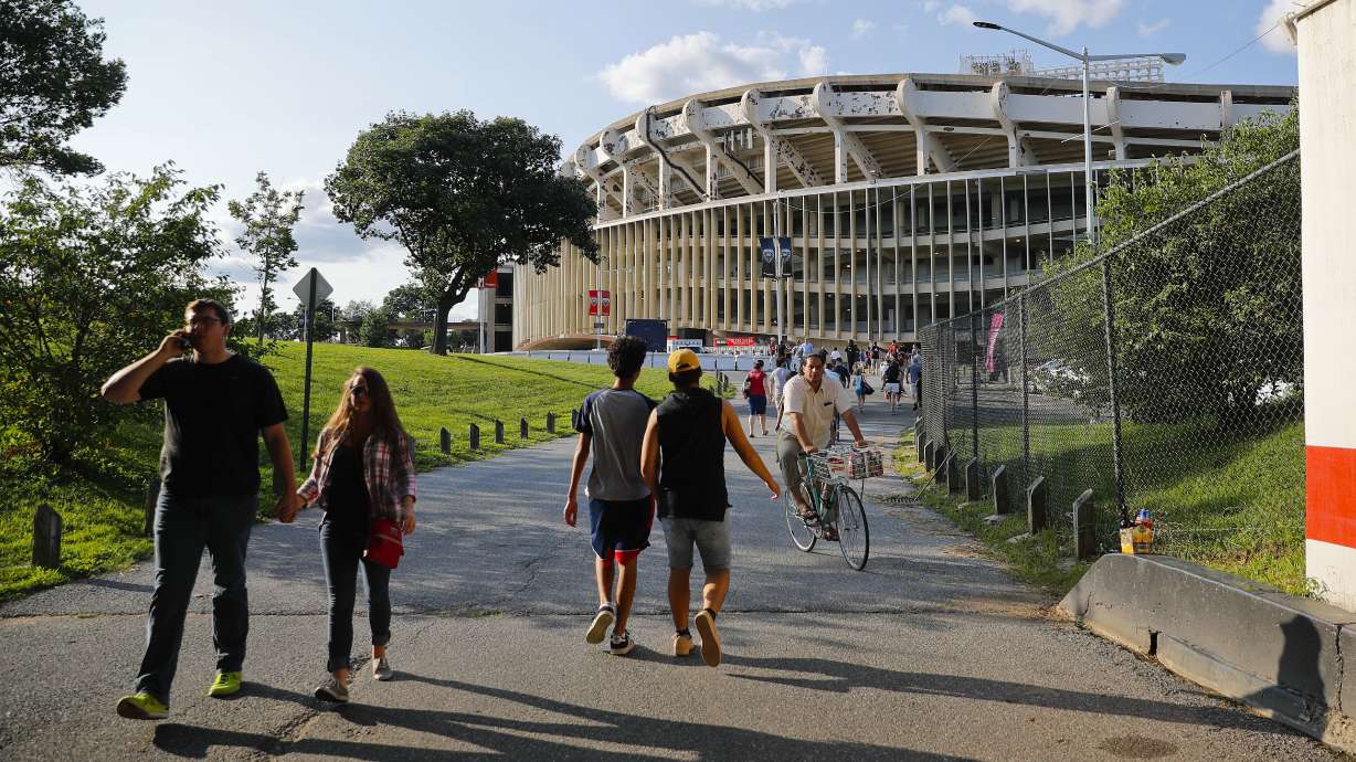 FILE - People make their way to RFK Stadium in Washington before the start of an MLS soccer match between D.C. United and Toronto FC, Saturday, Aug. 5, 2017. D.C.