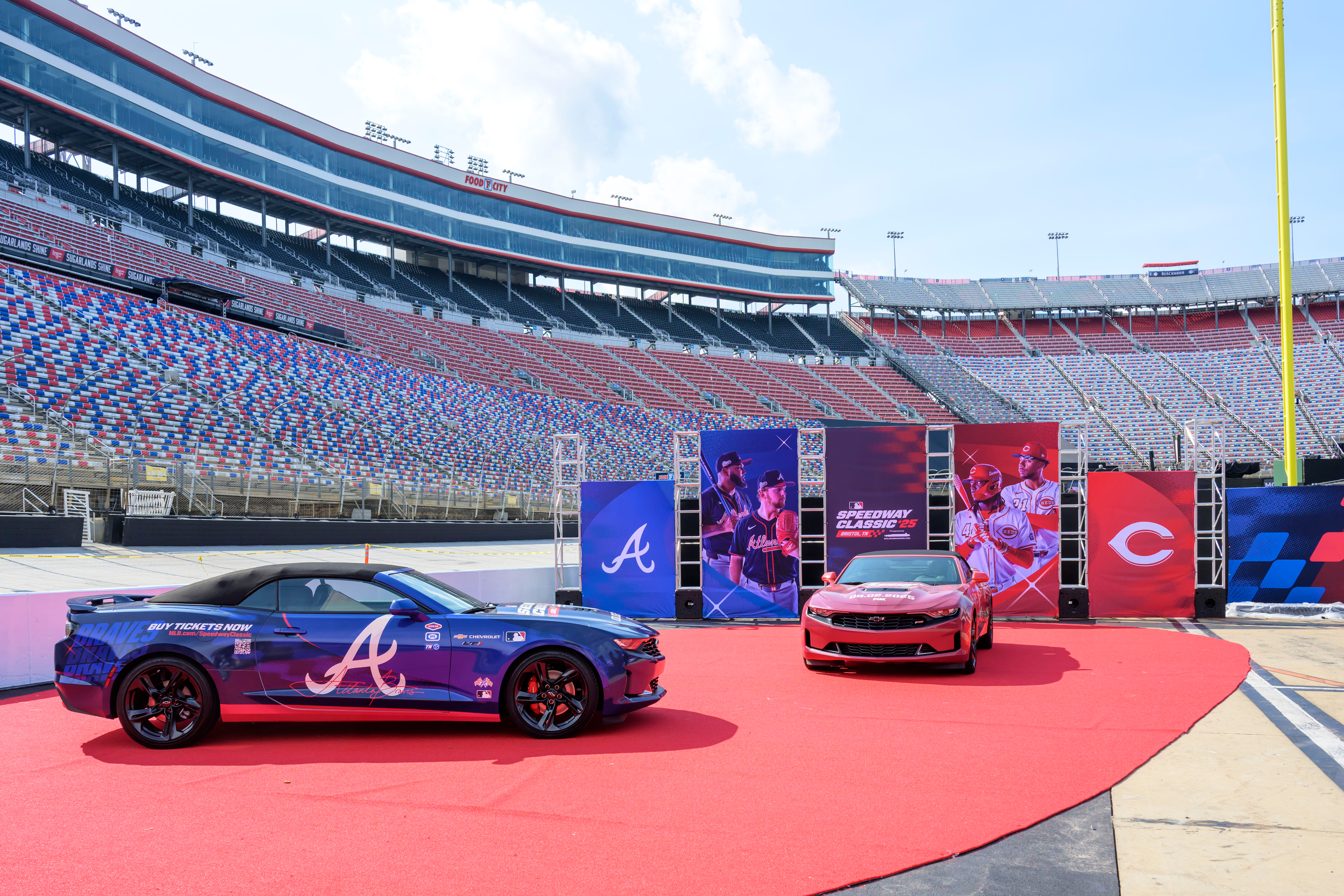 In this image provided by Bristol Moto Speedway, an Atlanta Braves, left, and Cincinnati Reds themed race cars are display at Bristol Motor Speedway, Thursday, July 31, 2025, in Bristol, Tenn., as preparations continue for the MLB Speedway Classic baseball game between the Reds and Braves on Aug. 2. (Earl Neikirk/Bristol Motor Speedway via AP