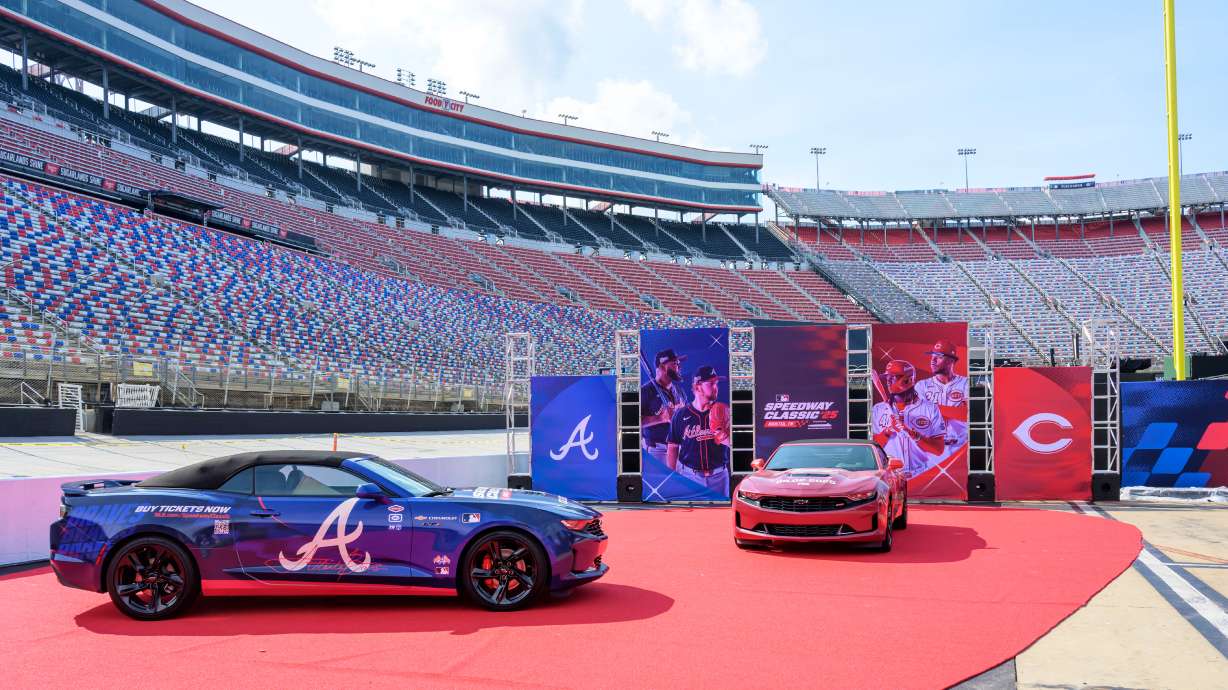 In this image provided by Bristol Moto Speedway, an Atlanta Braves, left, and Cincinnati Reds themed race cars are display at Bristol Motor Speedway, Thursday, July 31, 2025, in Bristol, Tenn., as preparations continue for the MLB Speedway Classic baseball game between the Reds and Braves on Aug. 2. (Earl Neikirk/Bristol Motor Speedway via AP