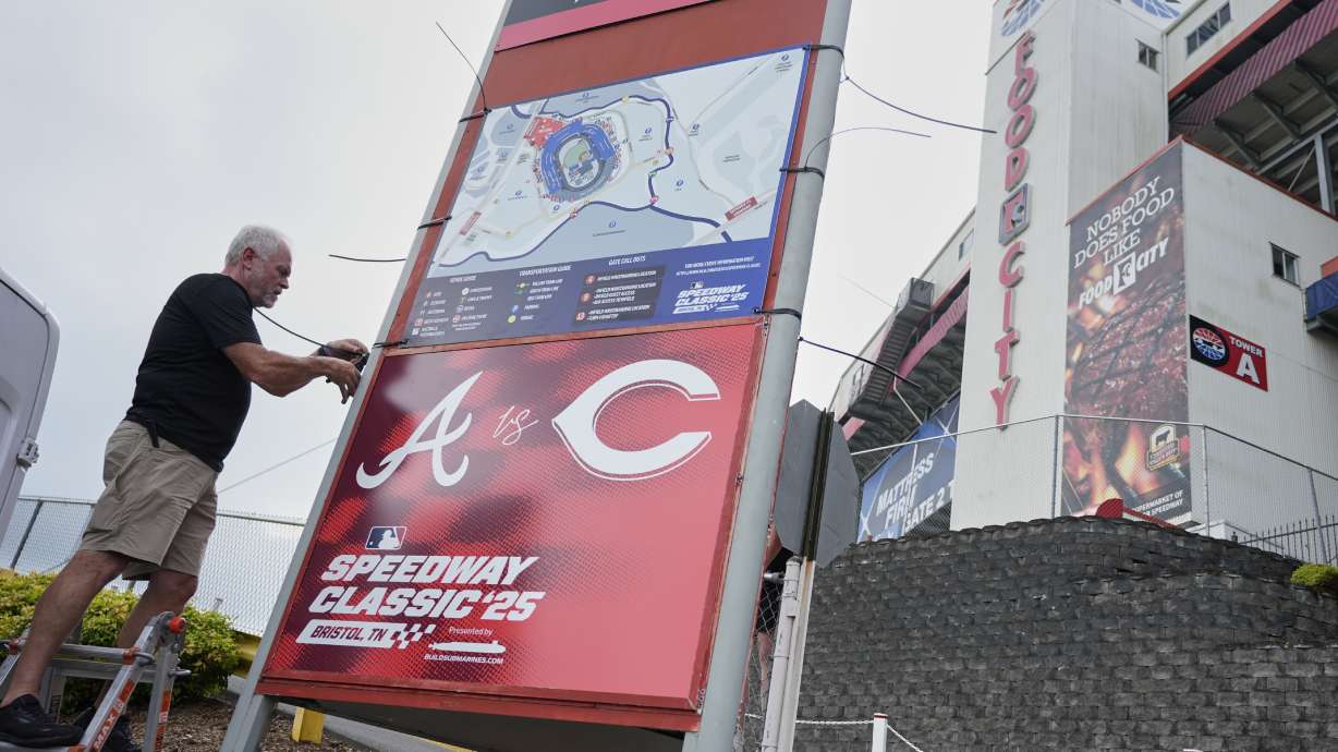 Rod Bruchell installs signs outside Bristol Motor Speedway, Friday, Aug. 1, 2025, in Bristol, Tenn., the day before the MLB Speedway Classic baseball game between the Cincinnati Reds and Atlanta Braves.