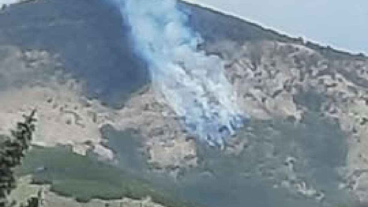 A fire burns on Mahogany Mountain Friday after a glider crashed into the mountain, sparking a small blaze. The pilot died in the crash, part of an eventful day for the Mountain Green Fire Protection District.