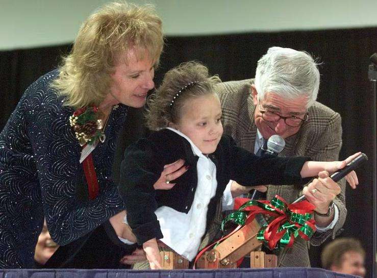 Annie Zarbock, a patient at Primary Children's Medical Center, center, turns on the lights for the 1998 Festival of Trees with help from Frank Layden, right, and Earlene Rex, festival chairwoman.