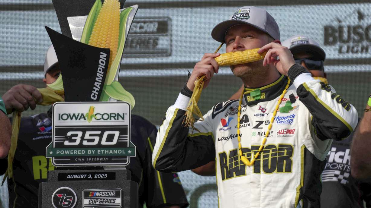 William Byron takes a bite of sweet corn in Victory Lane after winning a NASCAR Cup Series auto race, Sunday, Aug. 3, 2025, at Iowa Speedway in Newton, Iowa.