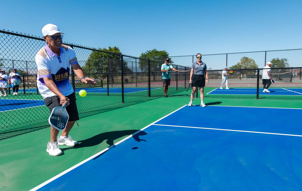 Ifa Motuliki, a longtime Glendale resident, serves the ball during a pickleball match with Salt Lake City officials on one of the 12 new pickleball courts at Glendale Regional Park in Salt Lake City on Saturday.